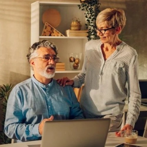 Santé, Banque & Assurance - Deux personnes agées se tiennent devant un ordinateur portable