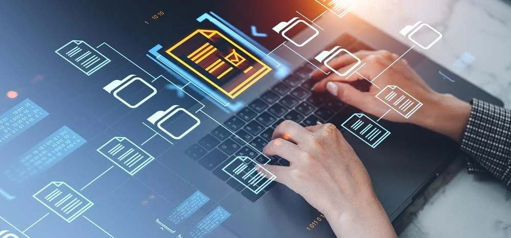 Main humaine interagissant avec une interface numérique de gestion de fichiers ou de données sur un ordinateur portable.