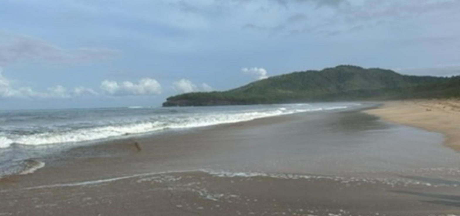 Walking Playa Grande beach in Guanacaste, Costa Rica, with the green headland at the north end