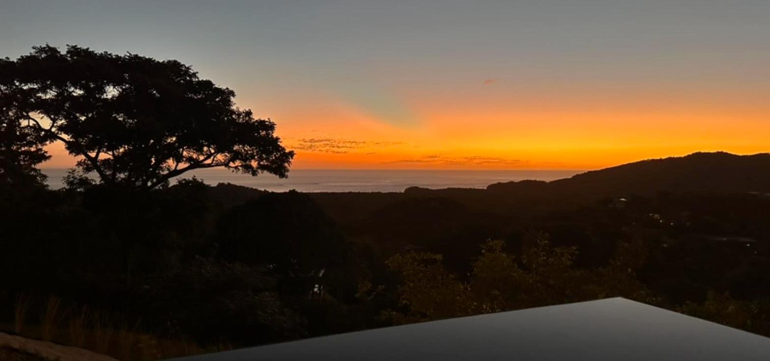 Sunset over the Pacific and the Playa Grande hills from the pool deck at Casa Perico Azul