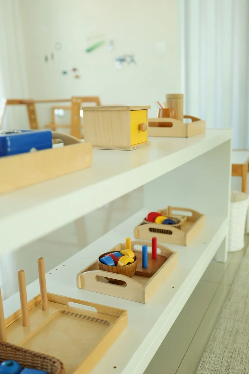 Materiais Montessori organizados em prateleiras baixas no ambiente preparado da Florescer.
