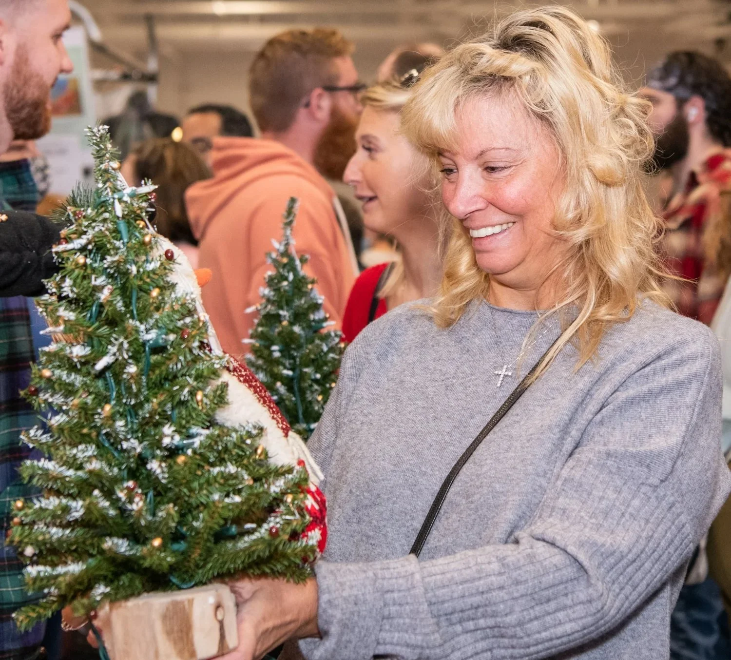 Smiling shopper carrying a handmade Christmas tree