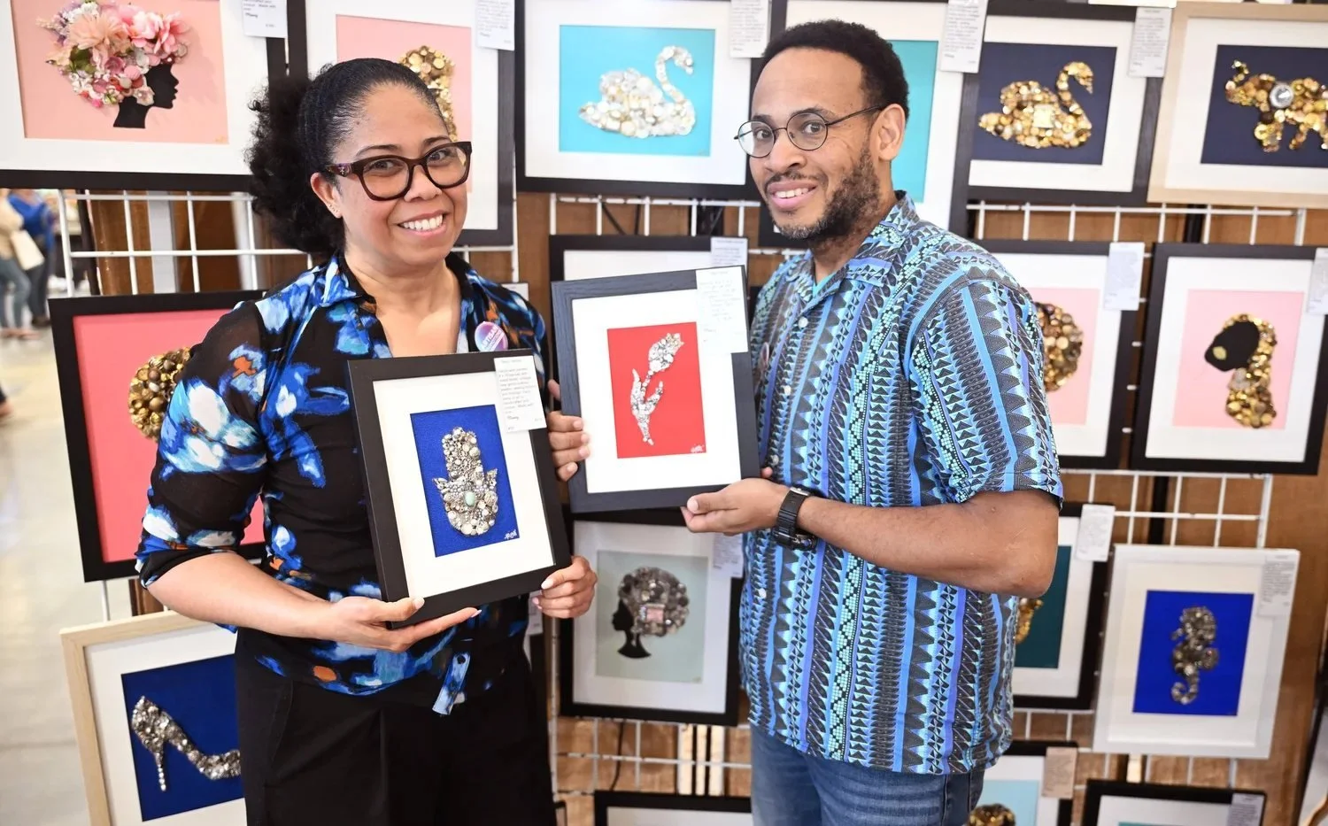 Artists holding framed artwork