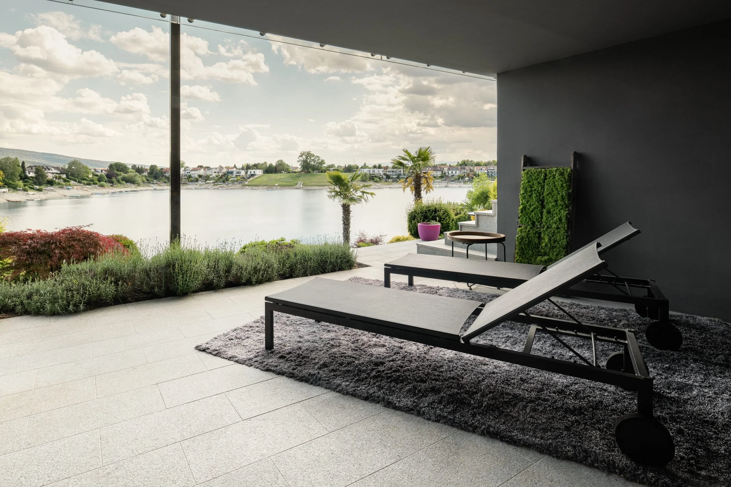 Gedeckte Terrasse mit Liegen und Seeblick