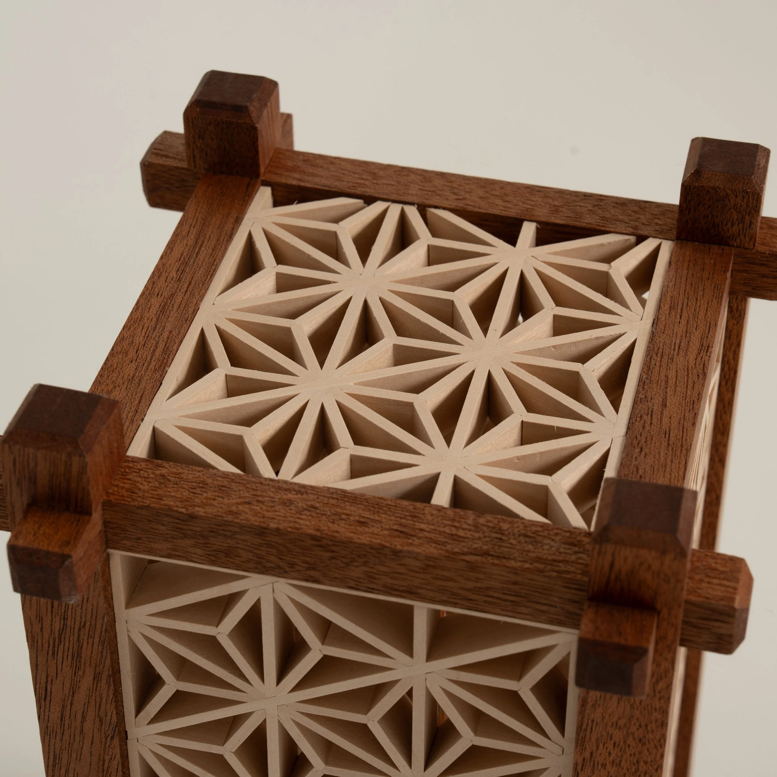 Detail van het houten bovenpaneel van de Yoake-lamp met geometrisch Kumiko-patroon.