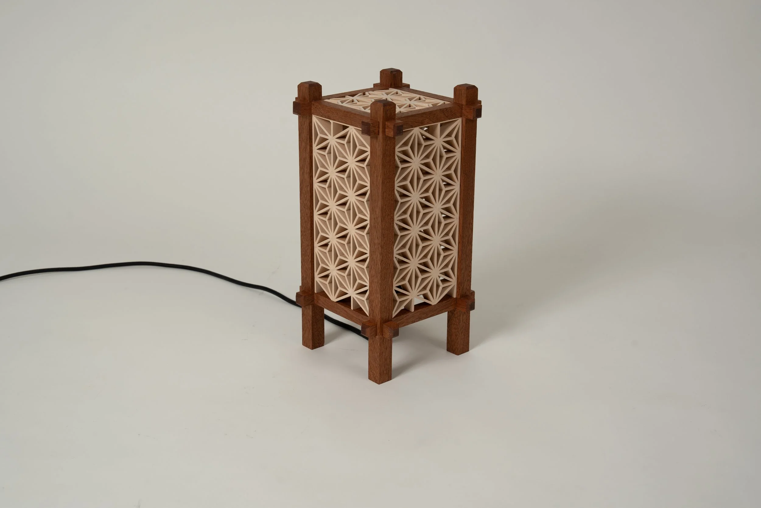 Handgemaakte Yoake-tafellamp met houten frame, Kumiko-panelen en zichtbaar snoer.