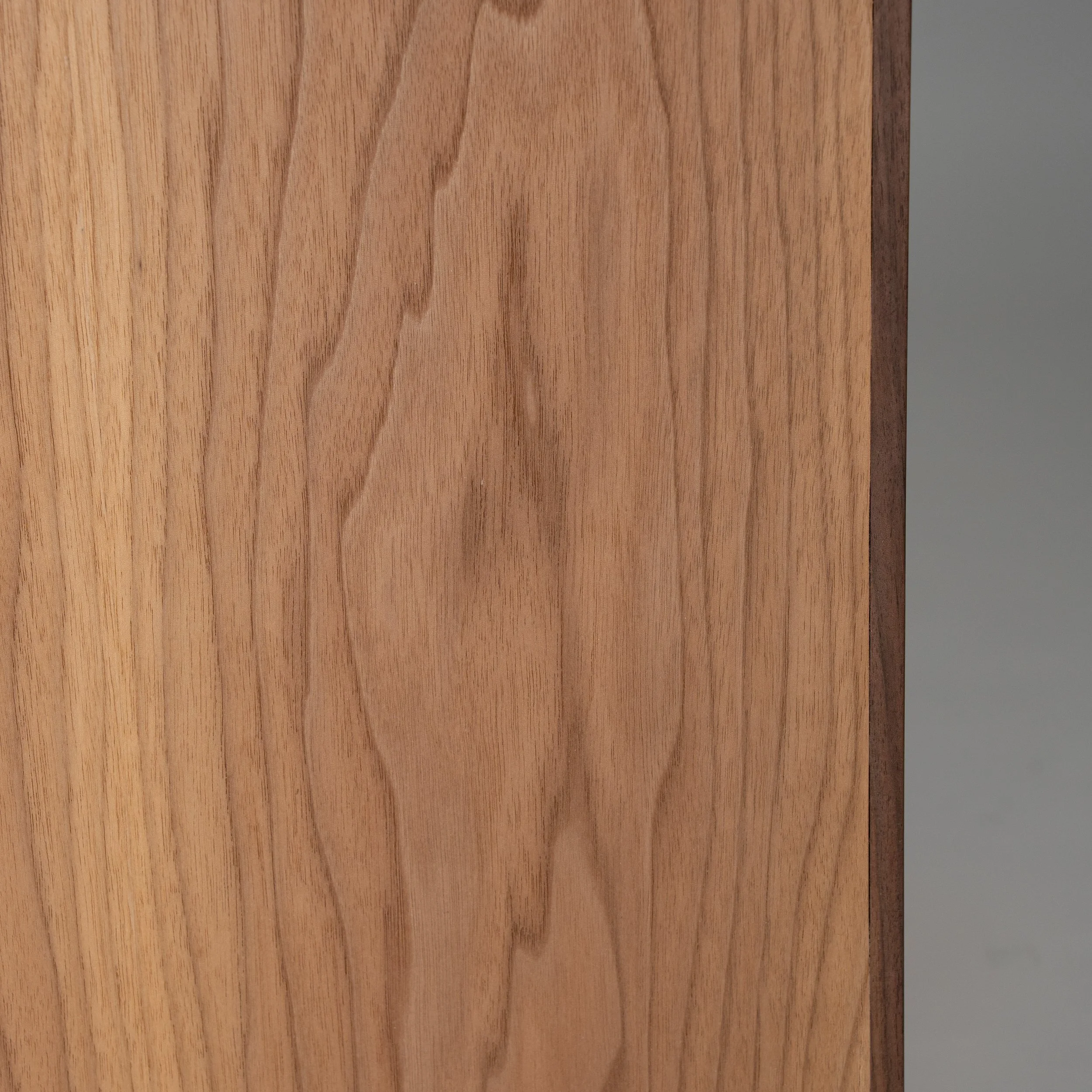 Detail van het walnoothout met zichtbare houtnerf en natuurlijke kleurnuances van de Kajino-audiokast.