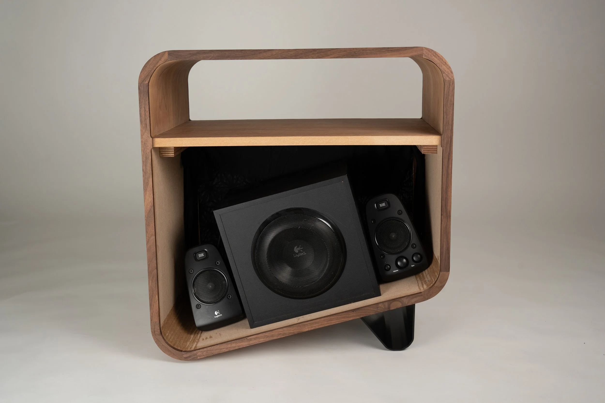 Een houten meubel met ingebouwde speakers, een subwoofer en twee kleinere luidsprekers.