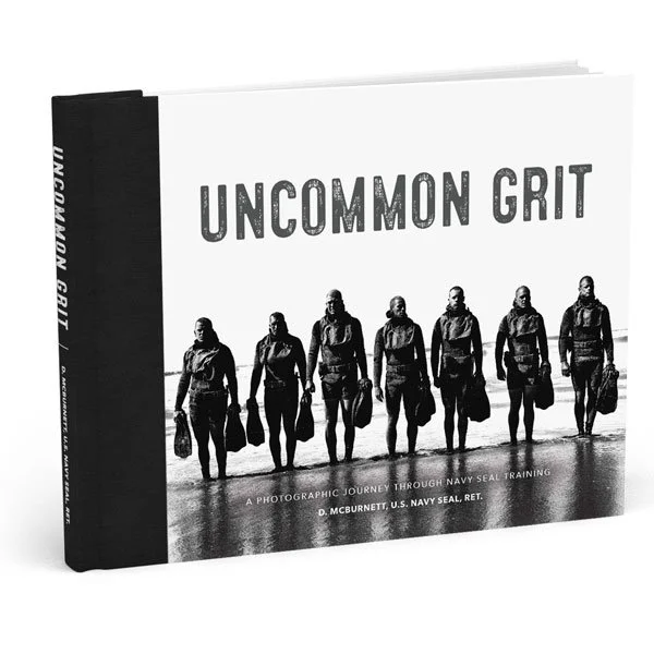 Hardcover book titled 'Uncommon Grit' with a photo of seven men in military gear on the beach.