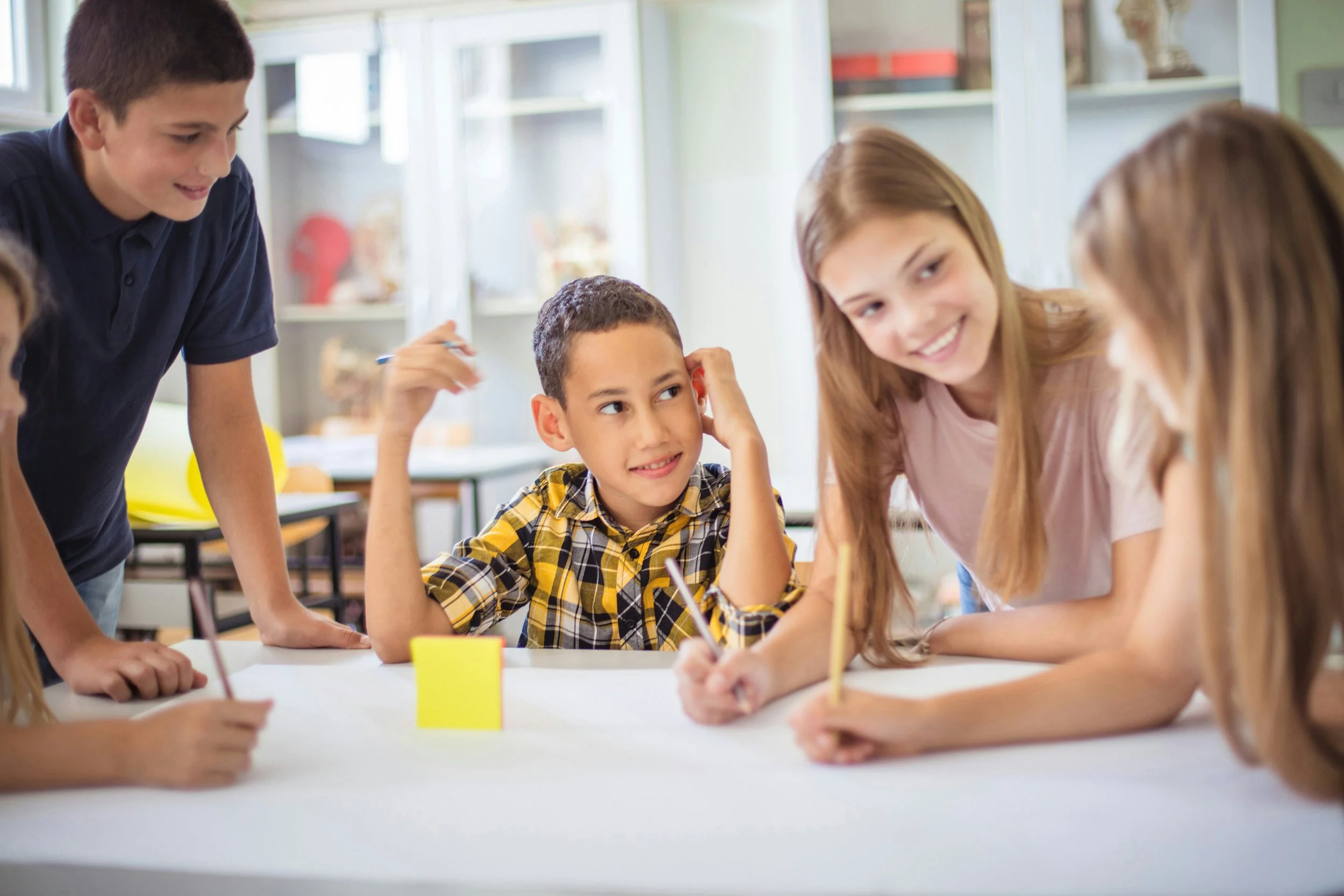 Diverse group of children collaborating on a classroom project at a table