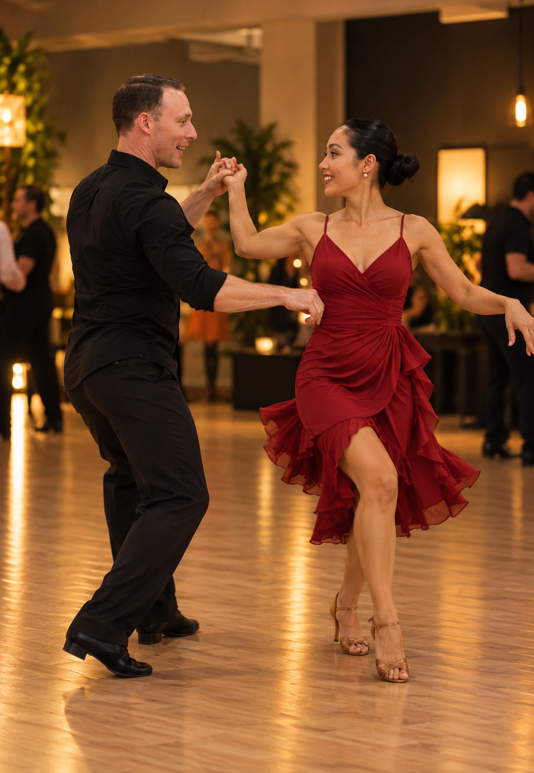 Partners practicing social dance steps, with the woman in a red dress