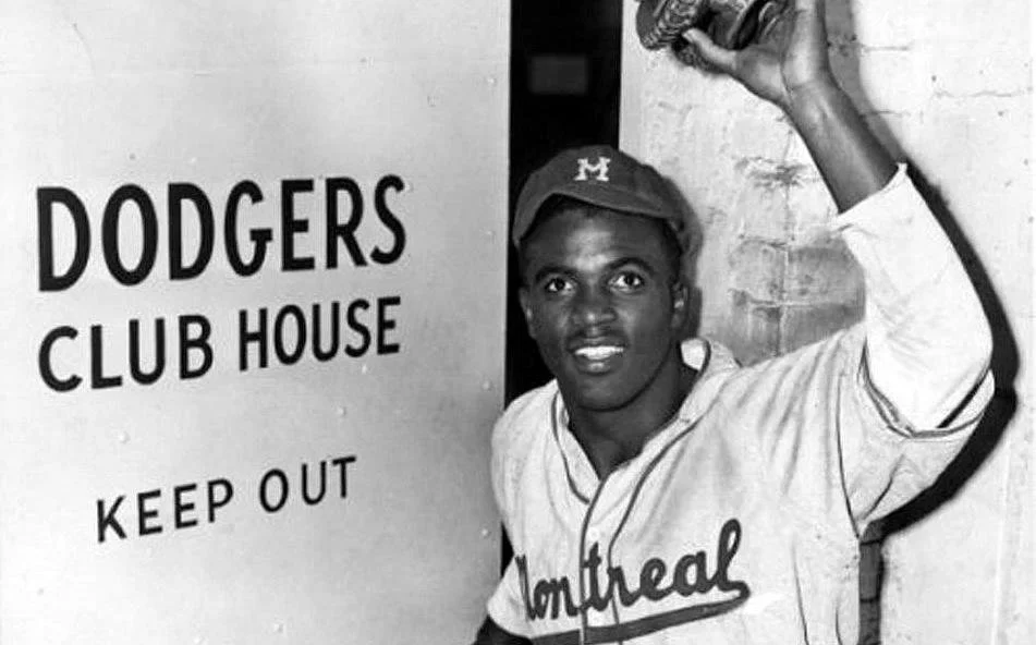 Jackie Robinson wearing his Montreal Royals uniform as he enters the Brooklyn Dodgers clubhouse in April 1947.