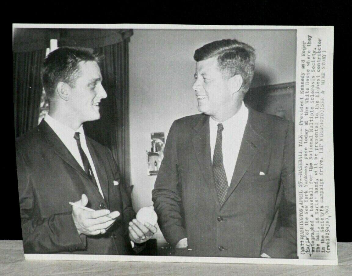 Roger Maris signs a baseball for President John F. Kennedy in the Oval Office in 1962.