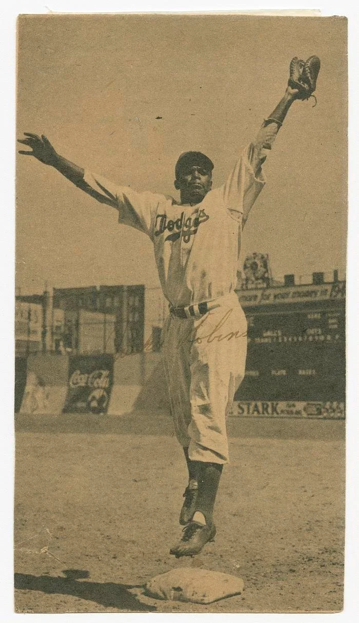 Jackie Robinson of the Brooklyn Dodgers leaps for a ball at Ebbets Field on April 15, 1947.