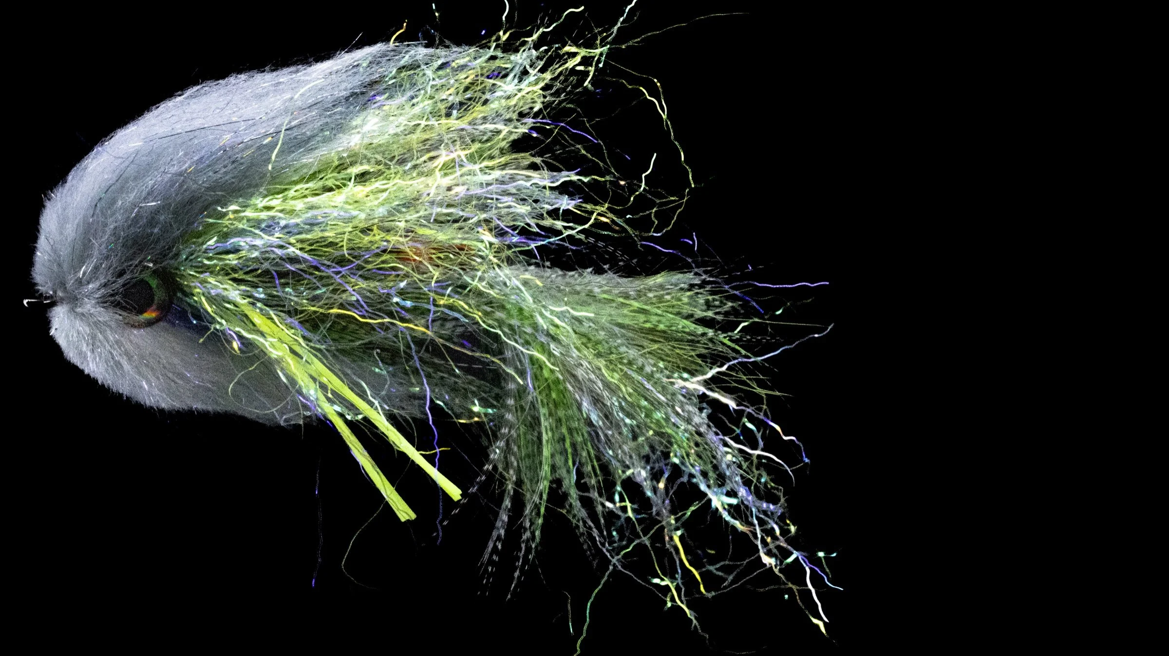 Finished white-and-chartreuse Code Blue fly against a dark background.
