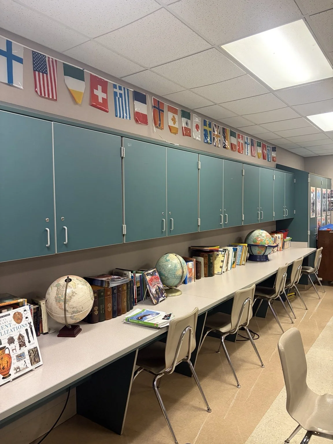 Globes, books, and international flags in Andy Blythe’s social studies classroom.