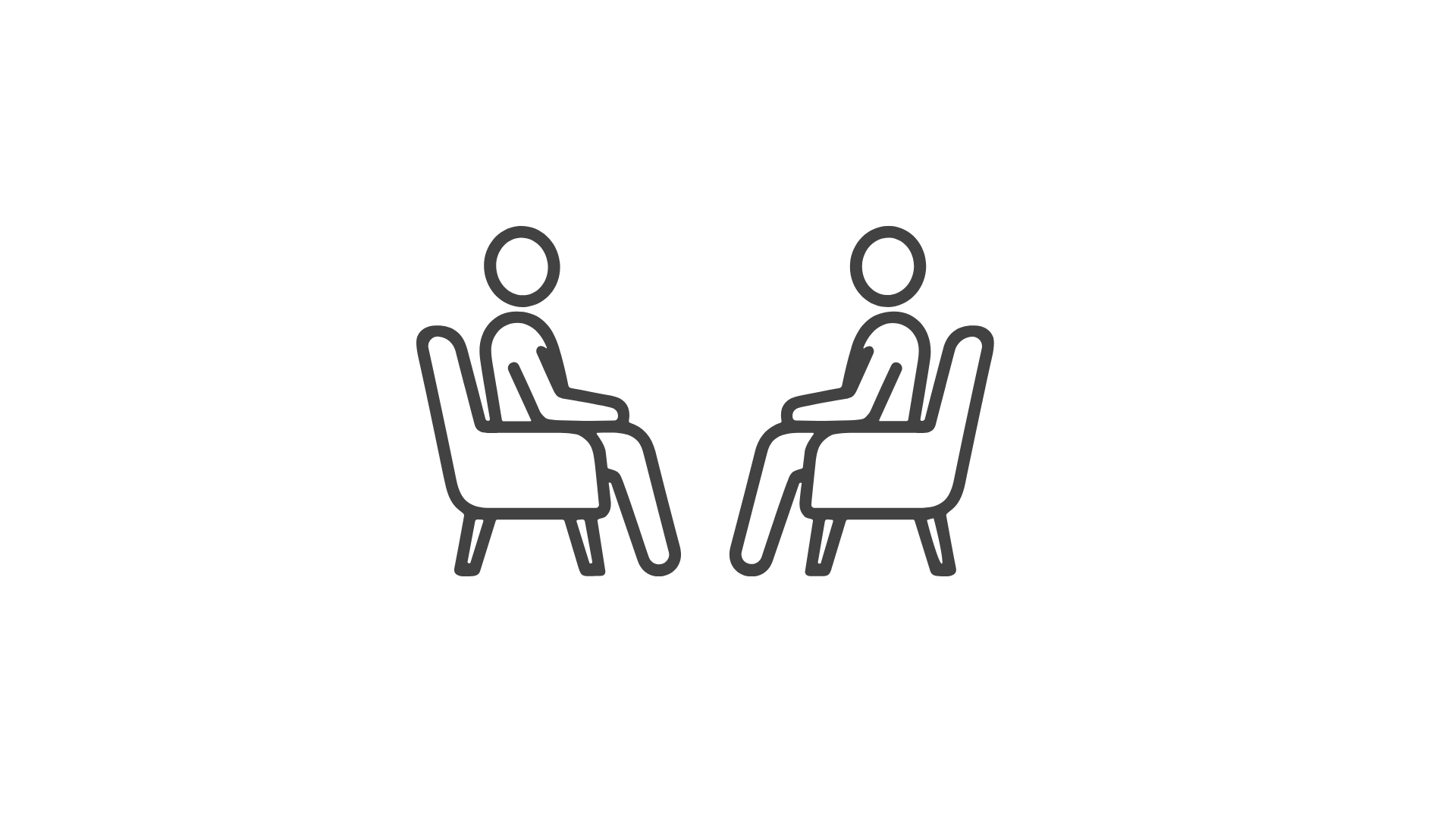 Two people sitting across from each other in chairs, facing each other, engaging in conversation.