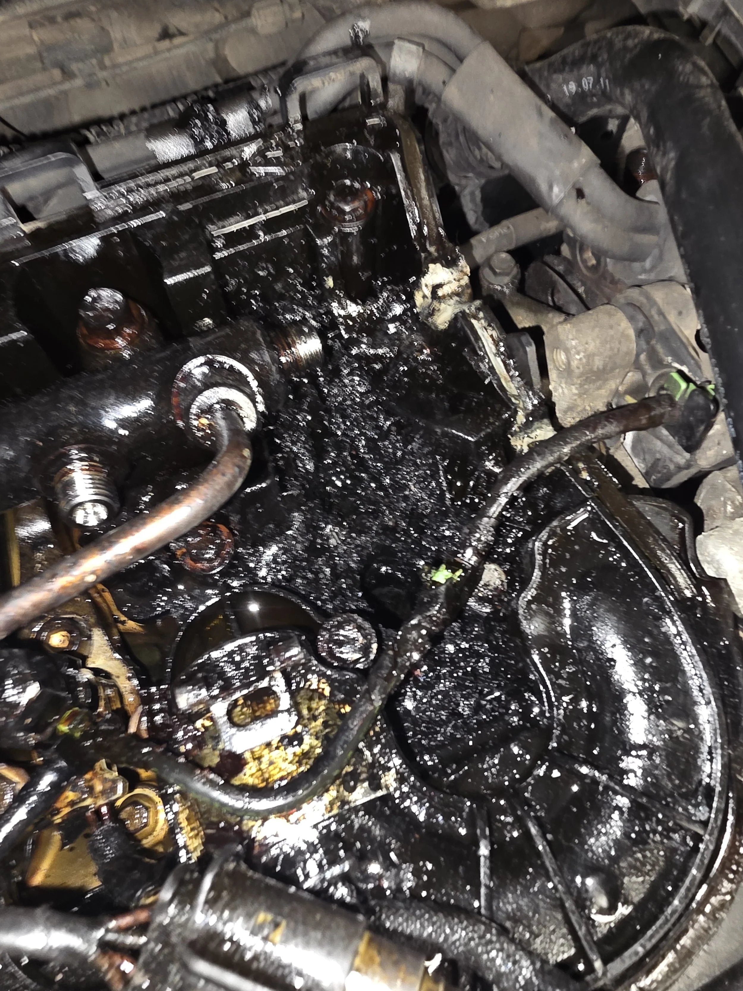 An engine with oil leakage and grime covering its components. example of a failed diesel injector seal