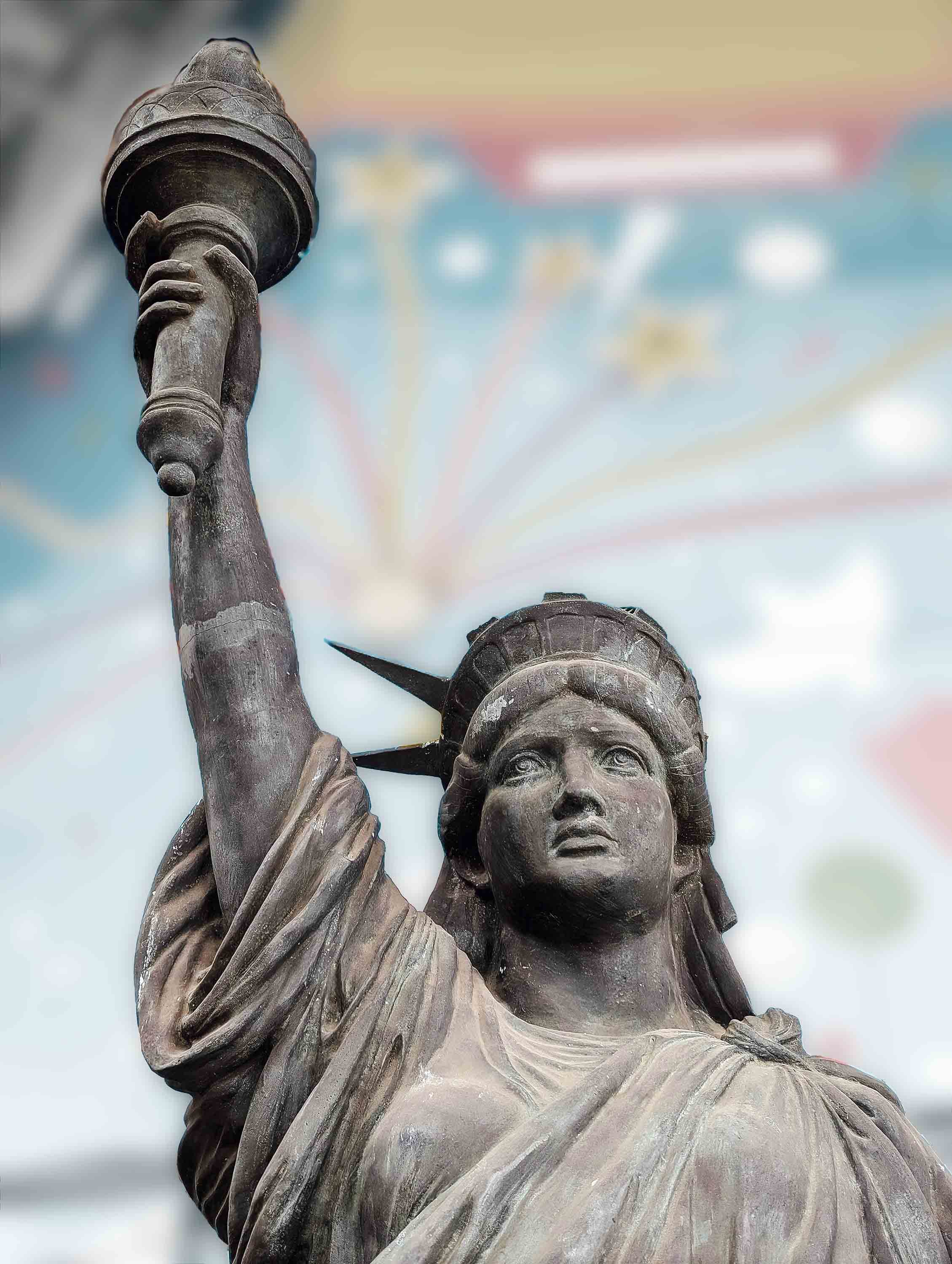 Slightly battered replica of Lady Liberty at a local fair. Photograph by Markus Winkler on Unsplash.