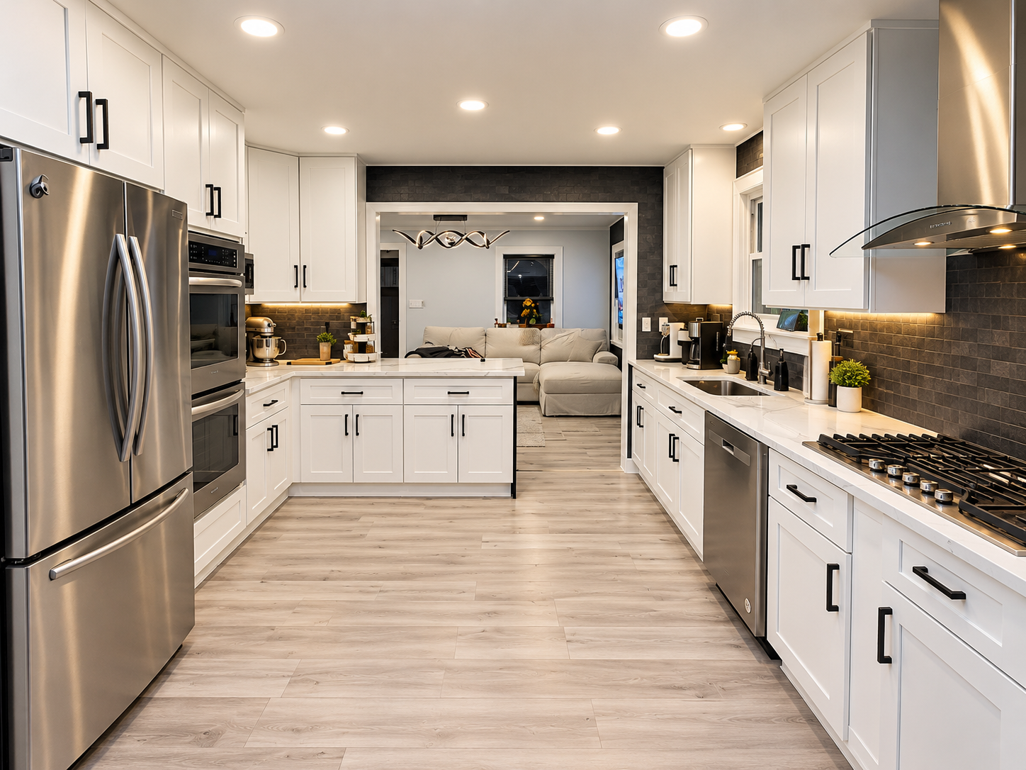Bright modern kitchen with white cabinets, stainless steel appliances, dark tile backsplash, central island, and adjoining living room