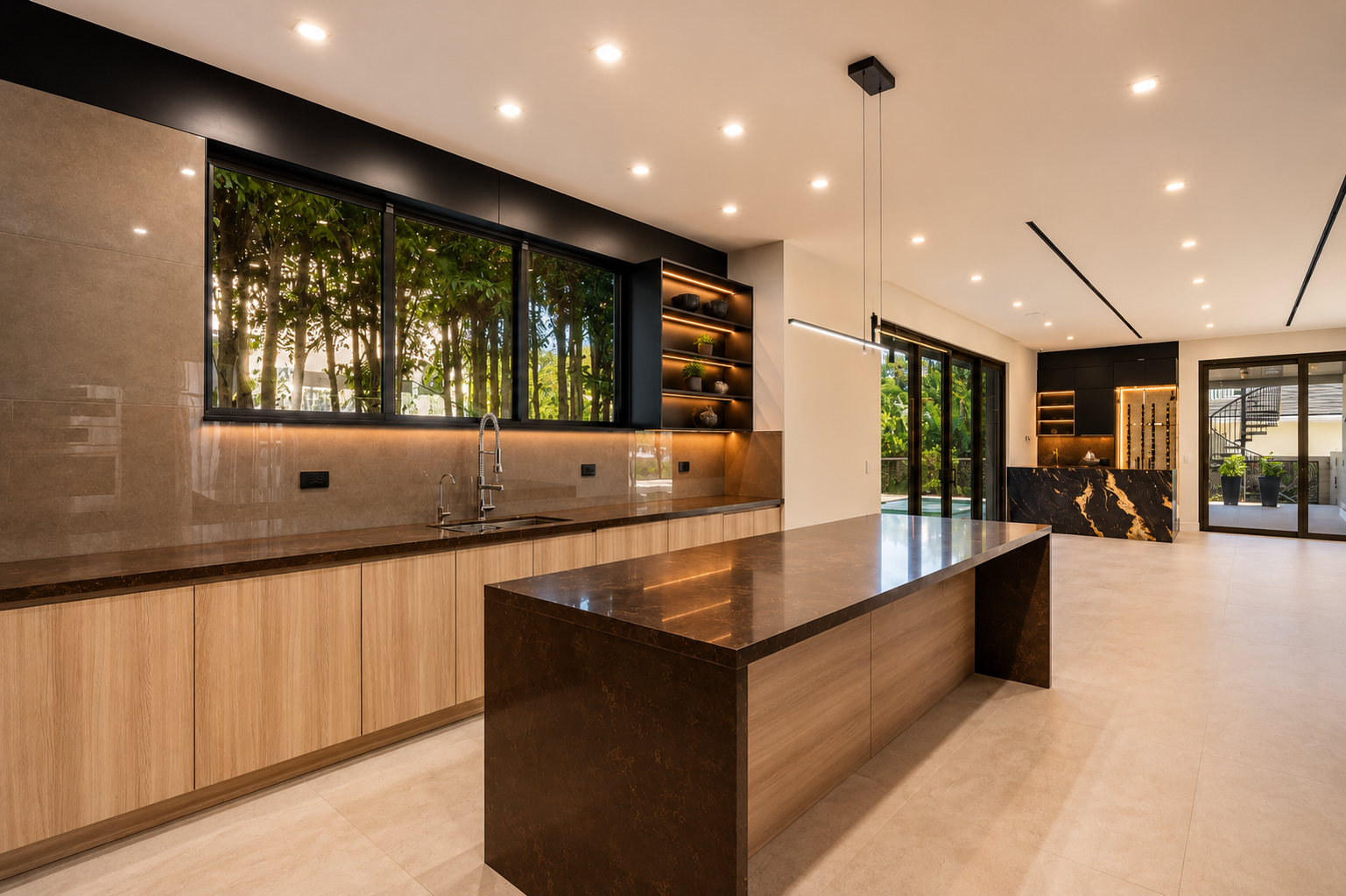 Modern luxury kitchen with a large marble island, wood cabinetry, black finishes, pendant lighting, and garden views through floor-to-ceiling windows