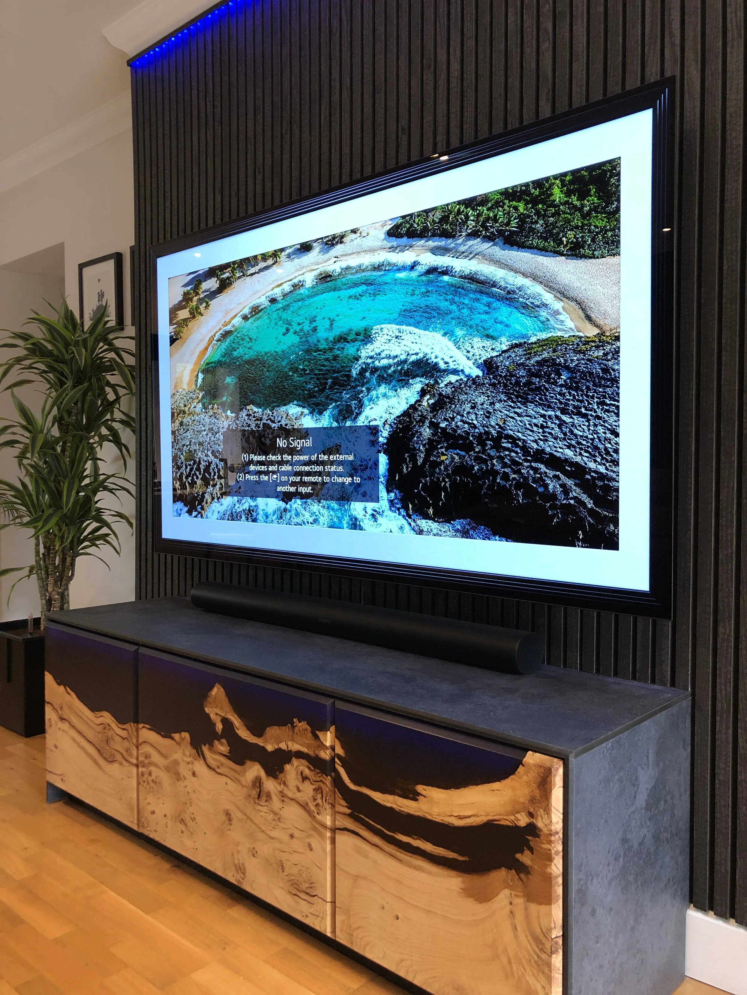 epoxy resin and oak tv media unit with grey translucent resin, photo taken on angle with large flat screen tv and LED lighting