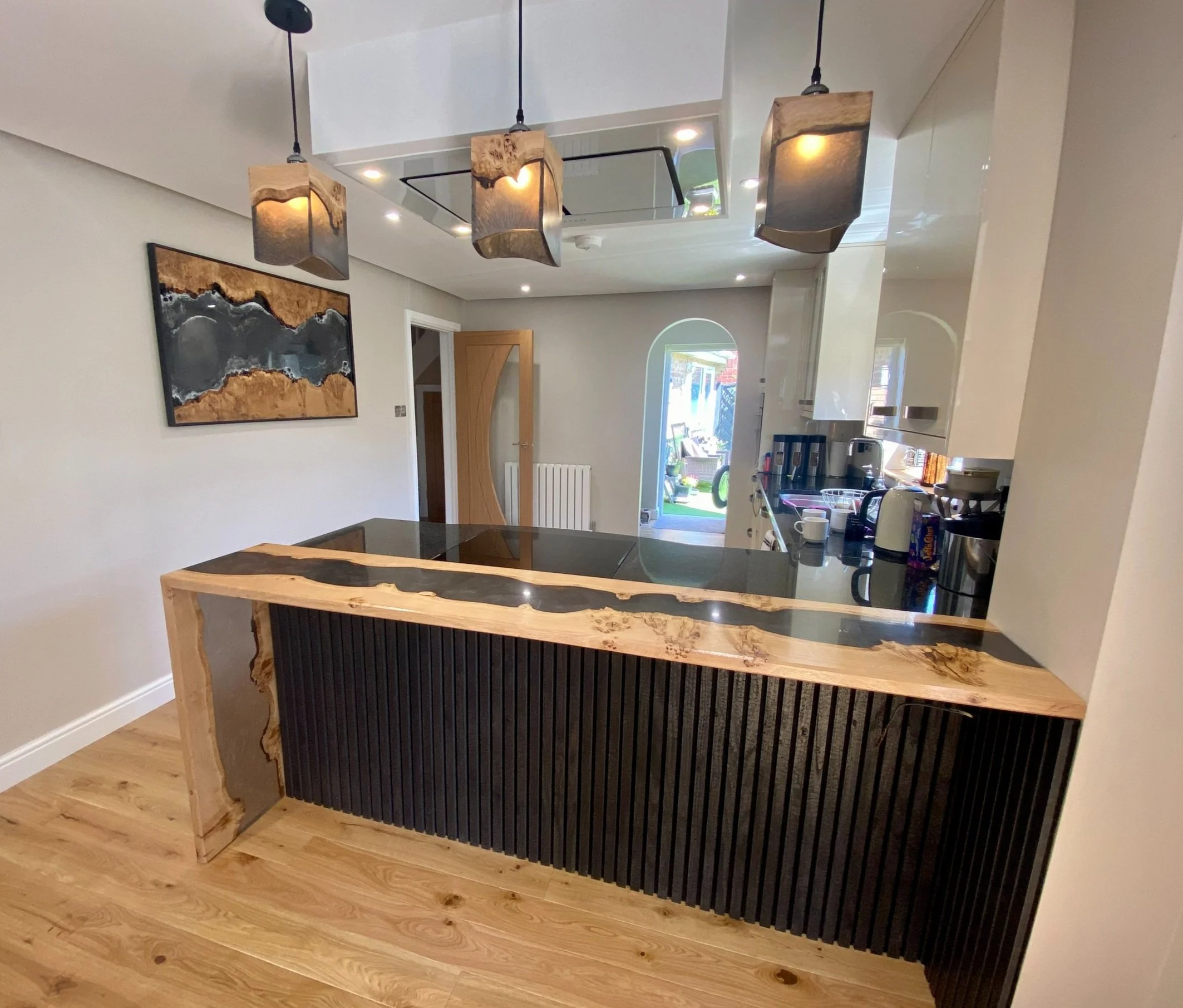 Epoxy resin waterfall leg breakfast bar with matching wall art and pendant lamps