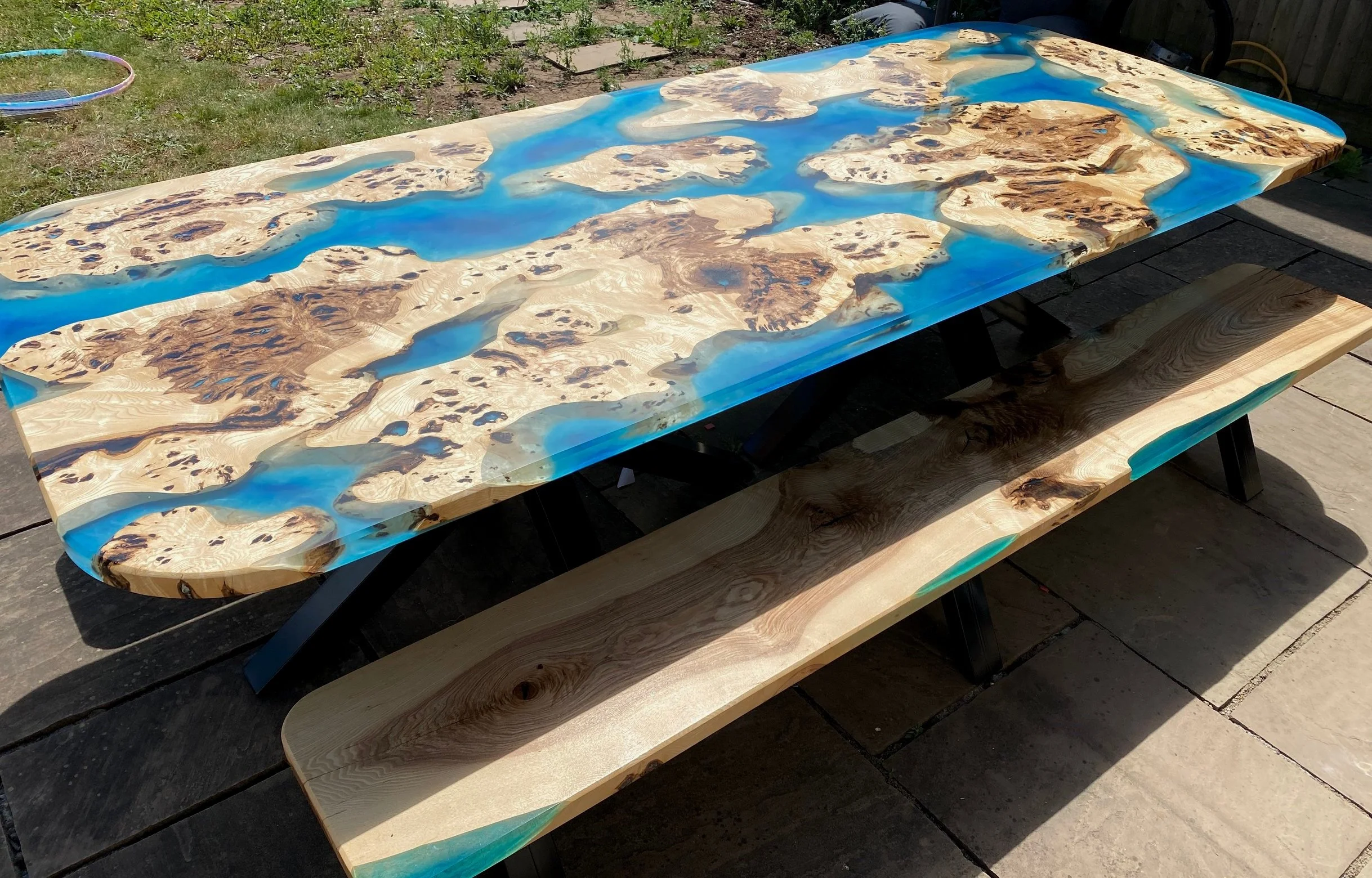 Large outdoor epoxy resin river table with ash and ocean effect