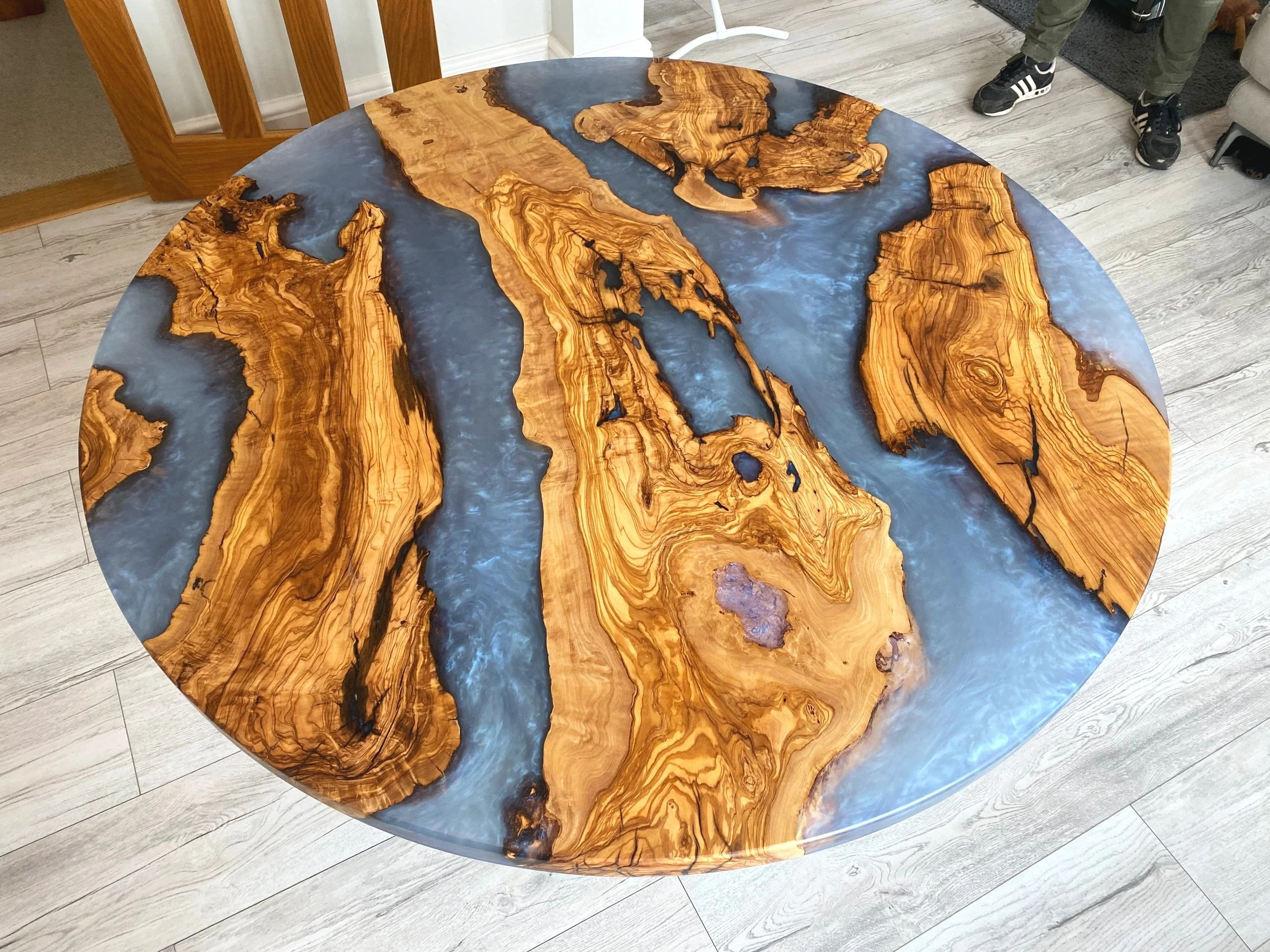 round epoxy resin dining table with olive wood and iridescent blue resin