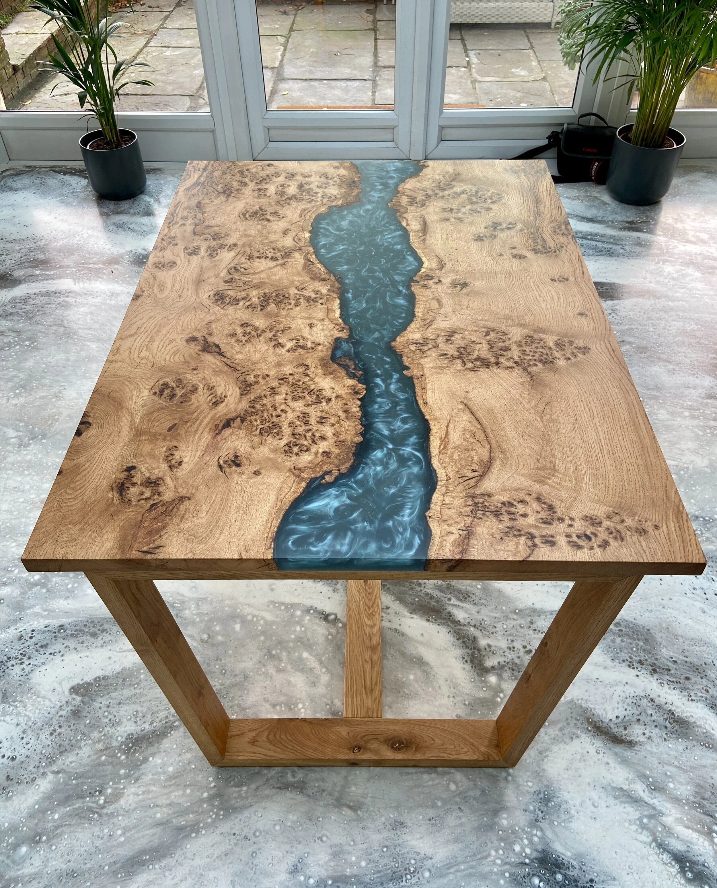 dining table with river effect top down on end angle with doors and plants in background