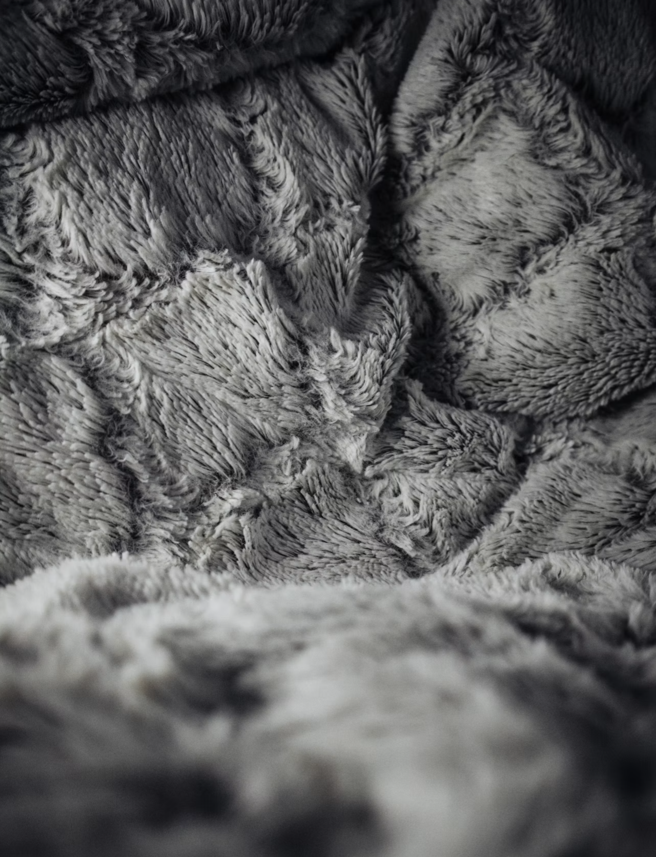 Close-up of soft, plush, grey faux fur fabric with a textured appearance.