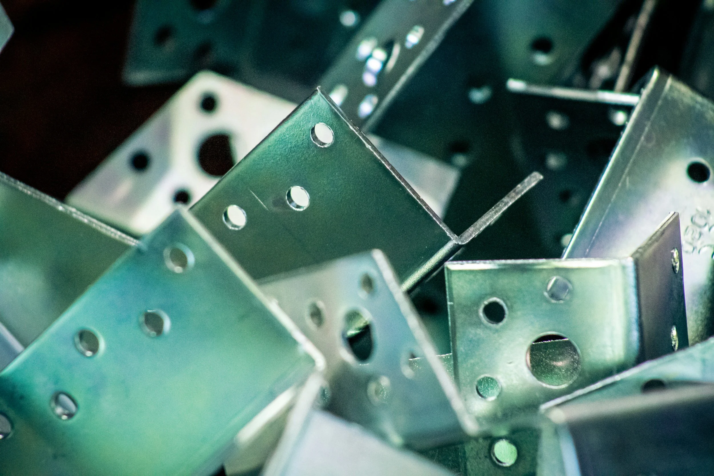 Close-up of assorted metal brackets and hardware with drilled holes
