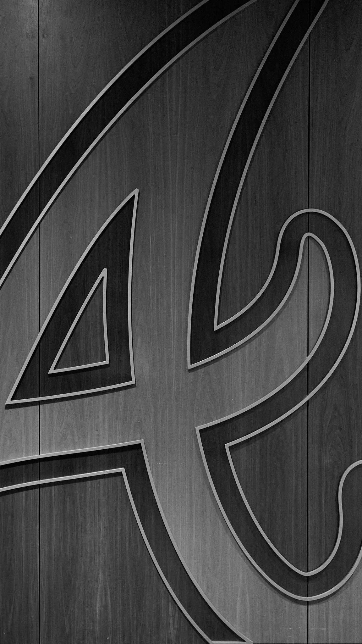 Close-up of a large Volvo logo on a dark wooden background.