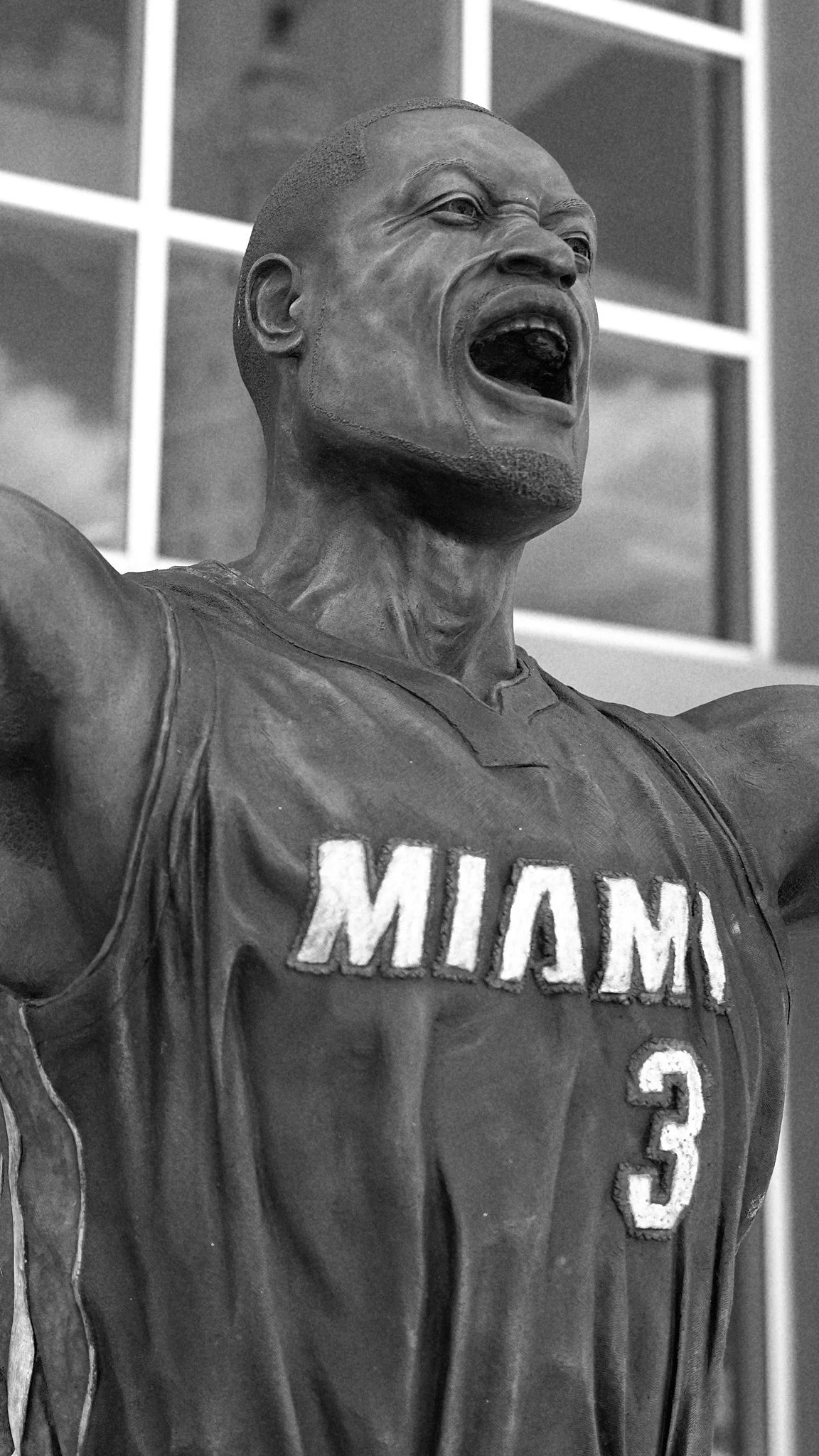 A statue of a person with arms raised, wearing a sports jersey that reads "MIAMI" and the number "3". The statue appears to be celebrating or rallying.