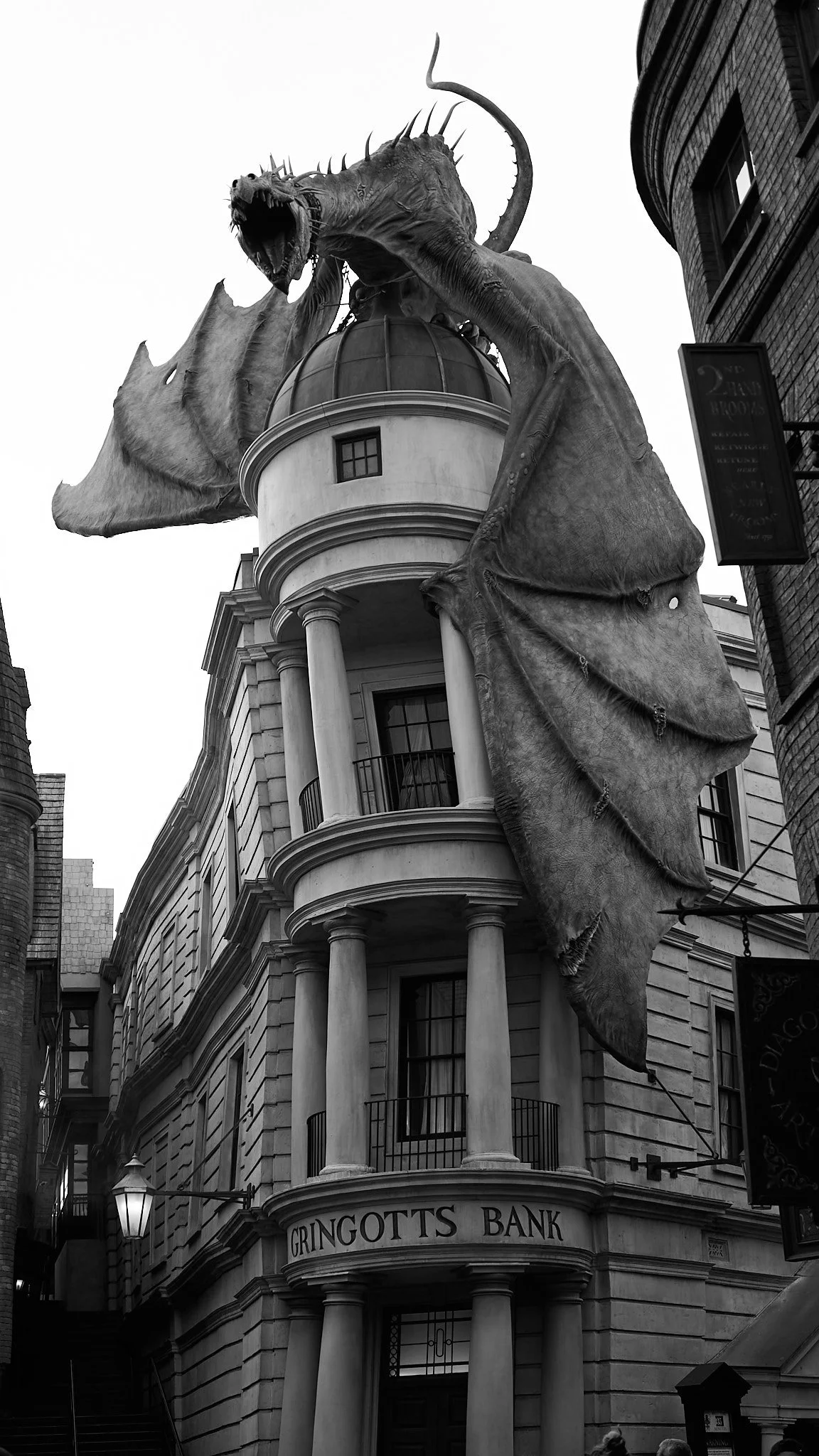 A large sculpture of a dragon on top of a building labeled 'Gringotts Bank'.