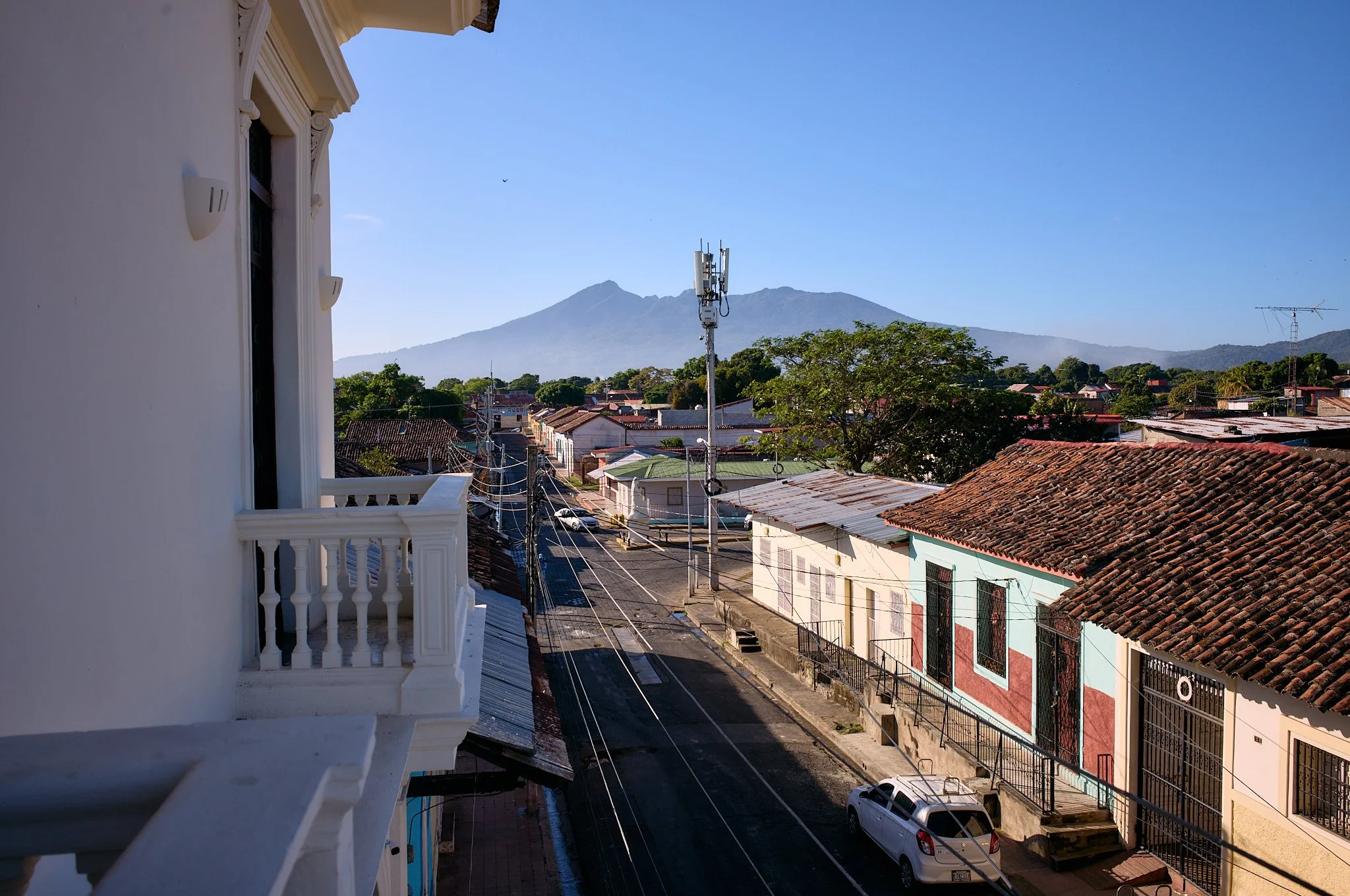 View of a street with colorful houses, a mountain in the background, and a clear blue sky.