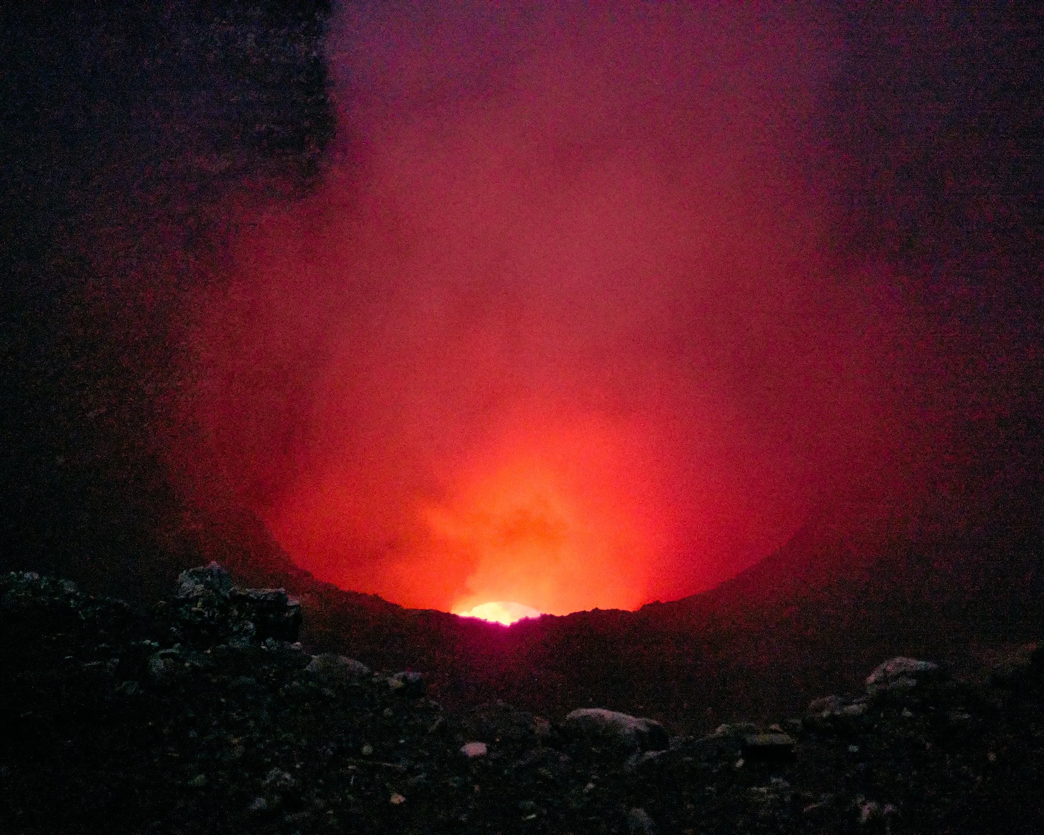 Volcano in Nicaragua erupting at night with bright glowing lava and smoke rising against a dark sky.