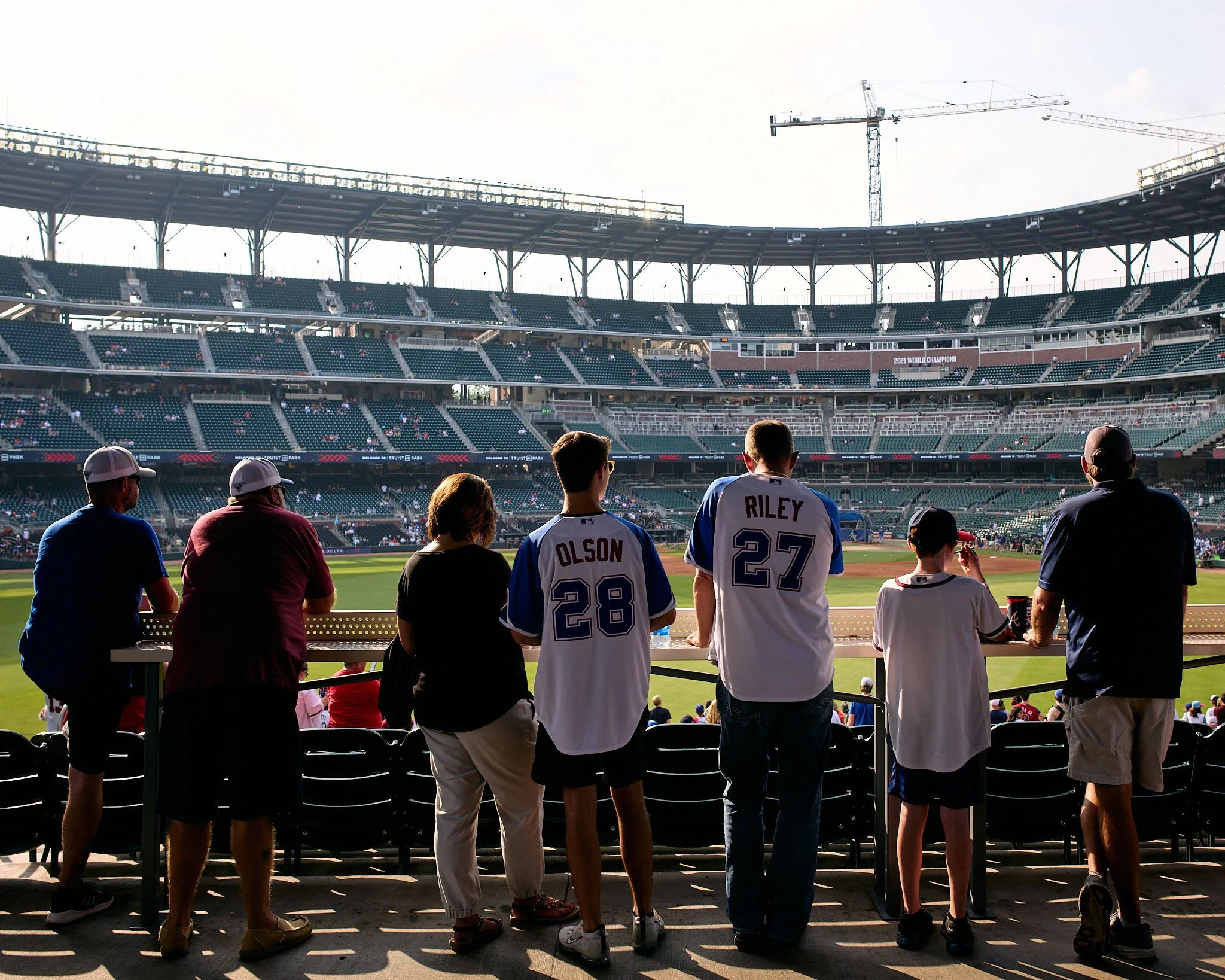 People watching a baseball game from the stands at a stadium.