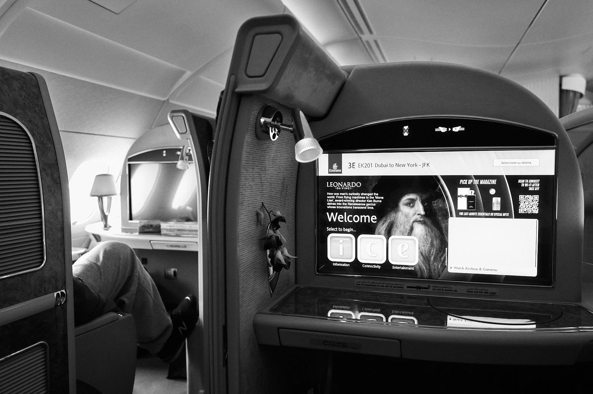 In-flight entertainment screen showing a welcome message and movie options on an airplane.