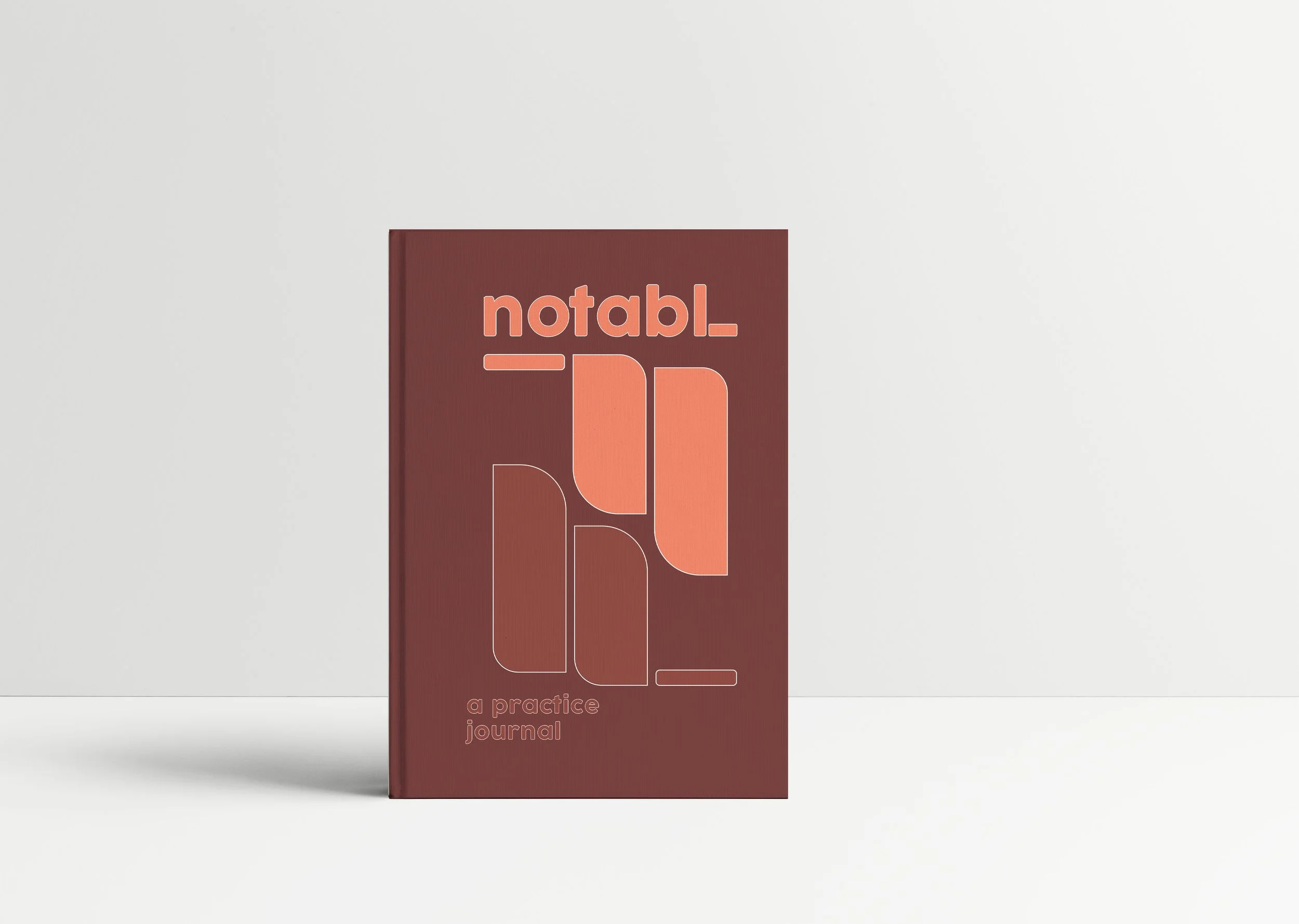Burgundy Notabl. practice journal mockup featuring coral geometric typography and a minimal abstract cover design.