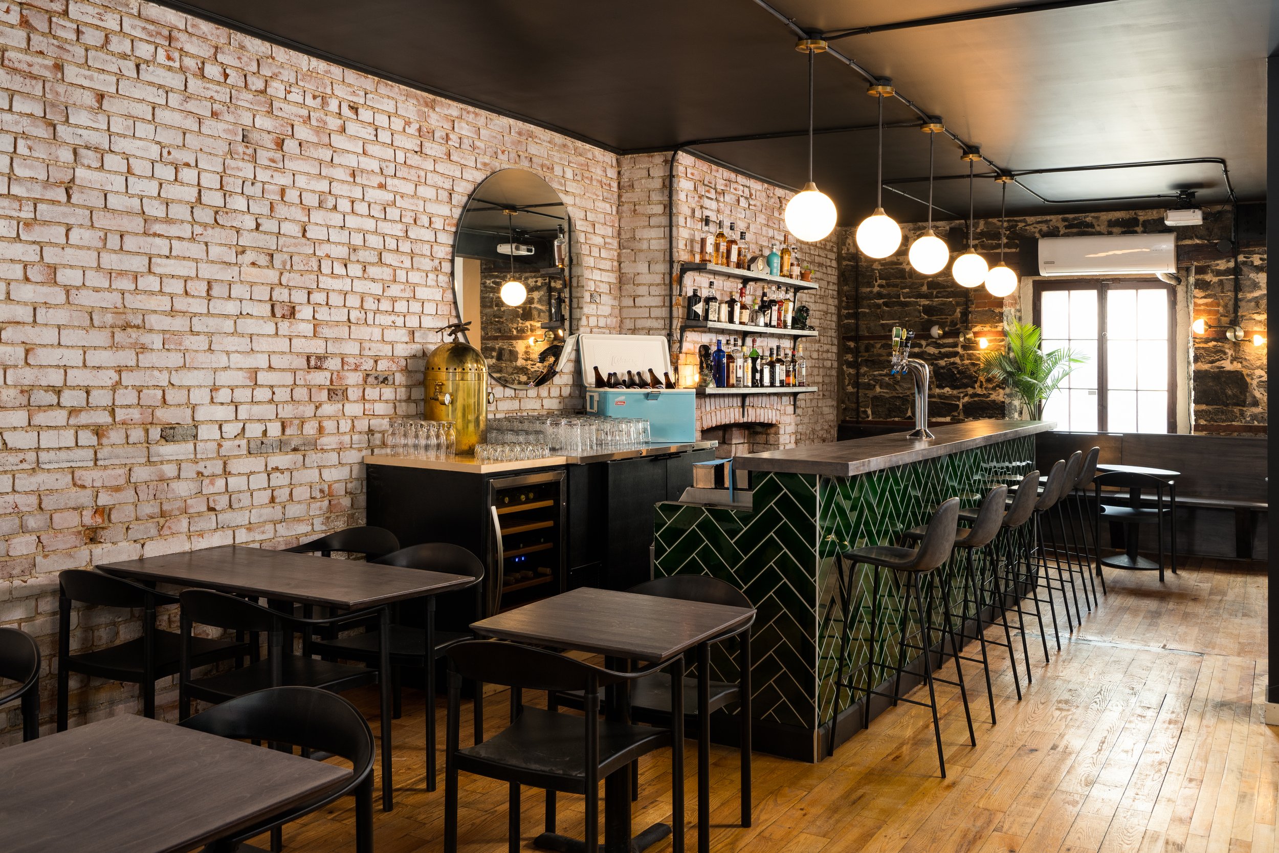 Interior design of Turbo Haus, a bar and live music venue in Montreal, featuring exposed brick walls, dark finishes and atmospheric lighting.