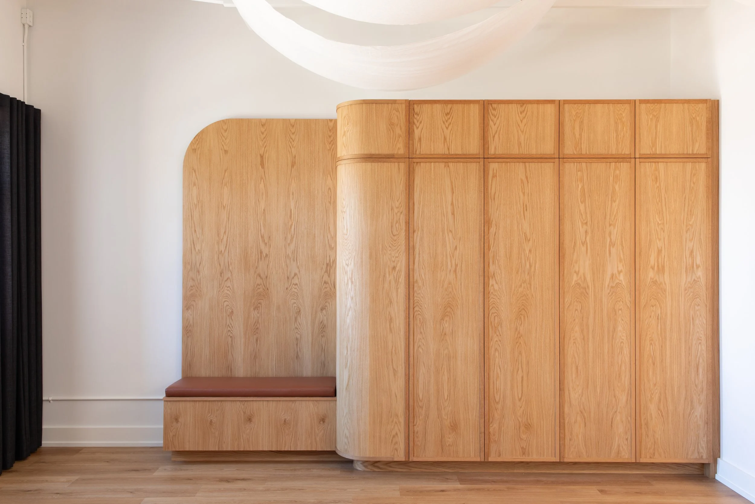 Custom oak cabinetry designed by Flodström Interiors for Wonderlit Studios in Toronto, featuring curved corner detailing, natural wood finishes and integrated storage.