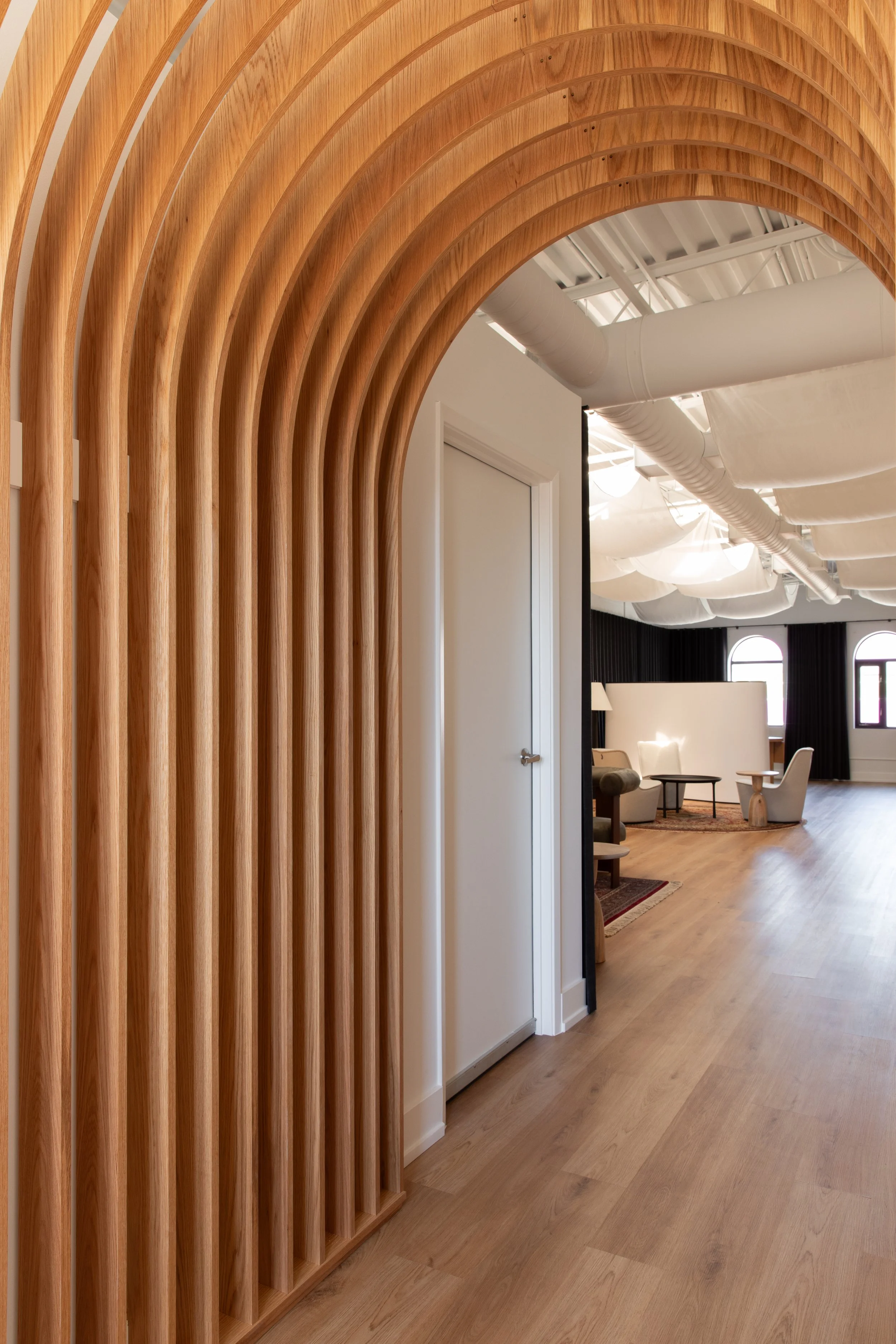 Close-up of a sculptural wood archway with repeated curved slats in the Wonderlit Studios interior.