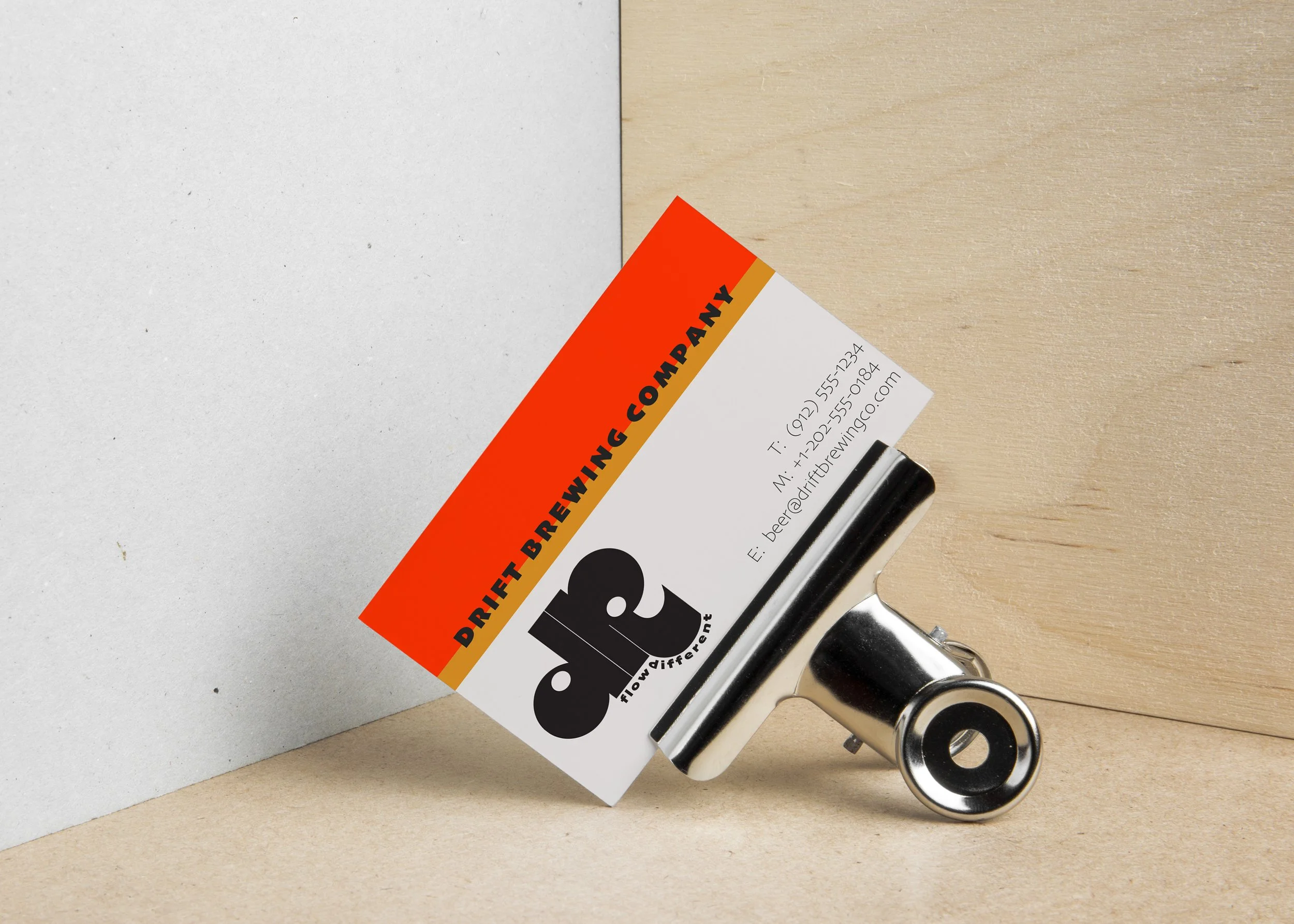 Drift Brewery business card concept featuring a bold orange diagonal stripe, black geometric logo and minimal contact information.