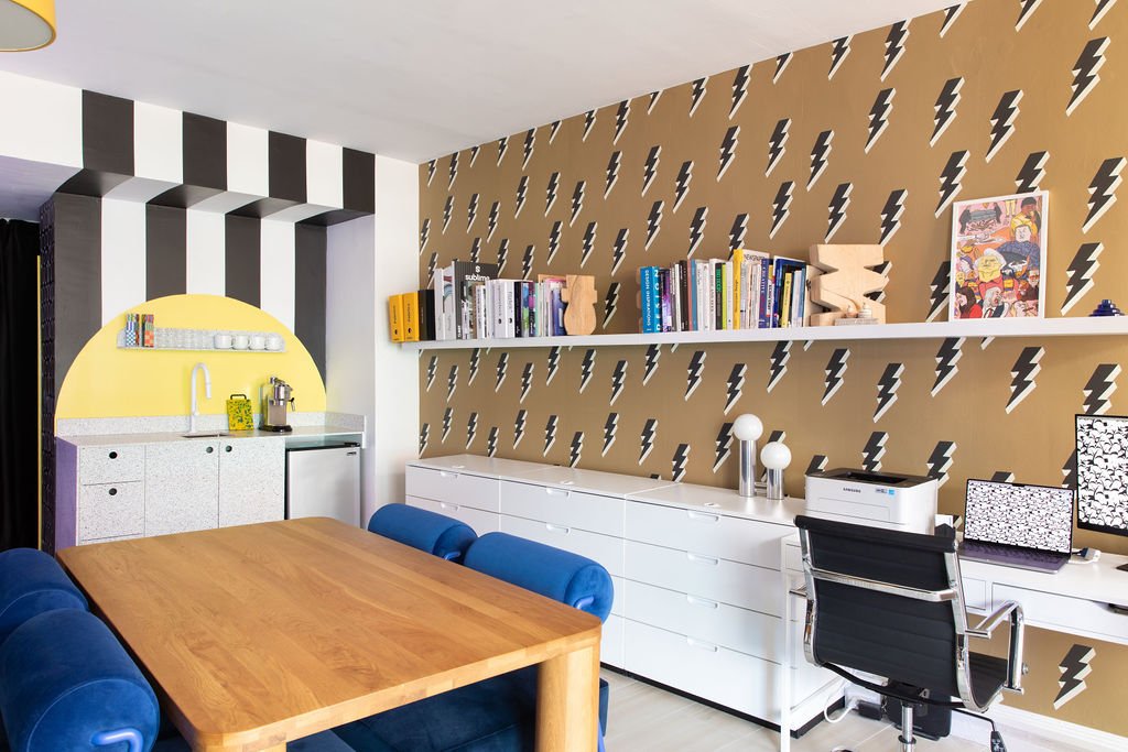 Toronto interior design studio with lightning bolt wallpaper, black-and-white striped archway, blue seating and a custom kitchenette.