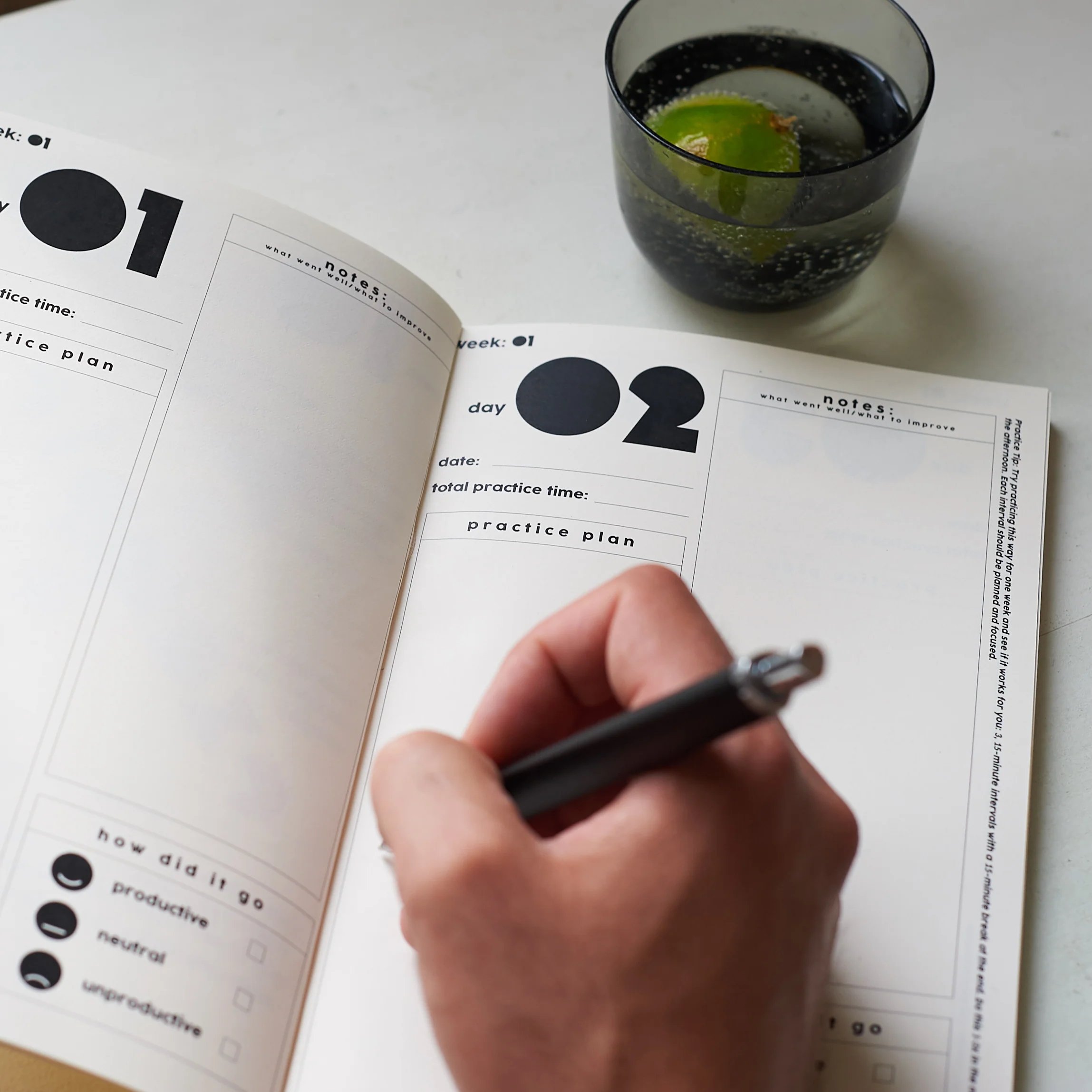 Person writing in an open Notabl. practice journal, showing daily practice plans, notes and self-assessment checkboxes.