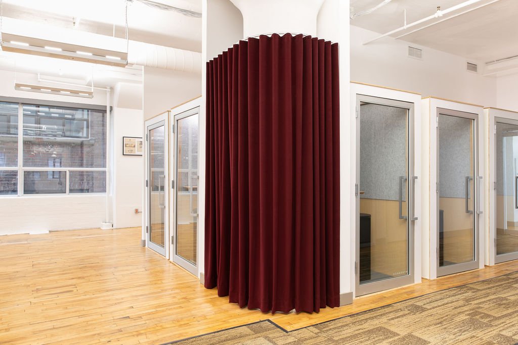 Glass-enclosed meeting rooms at the Chef's Plate Toronto office, designed by Flodström Interiors with floor-to-ceiling burgundy curtains, glass doors and exposed industrial ceilings.