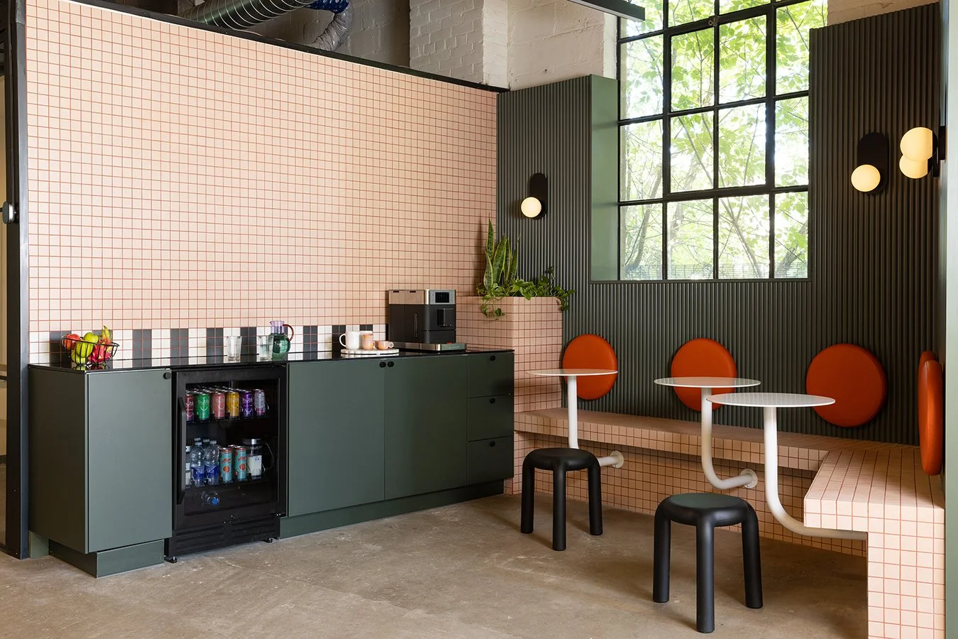 Toronto creative studio lounge with pale pink tiled banquette and olive green cabinetry