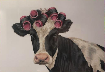 A cow with pink hair rollers in its head.