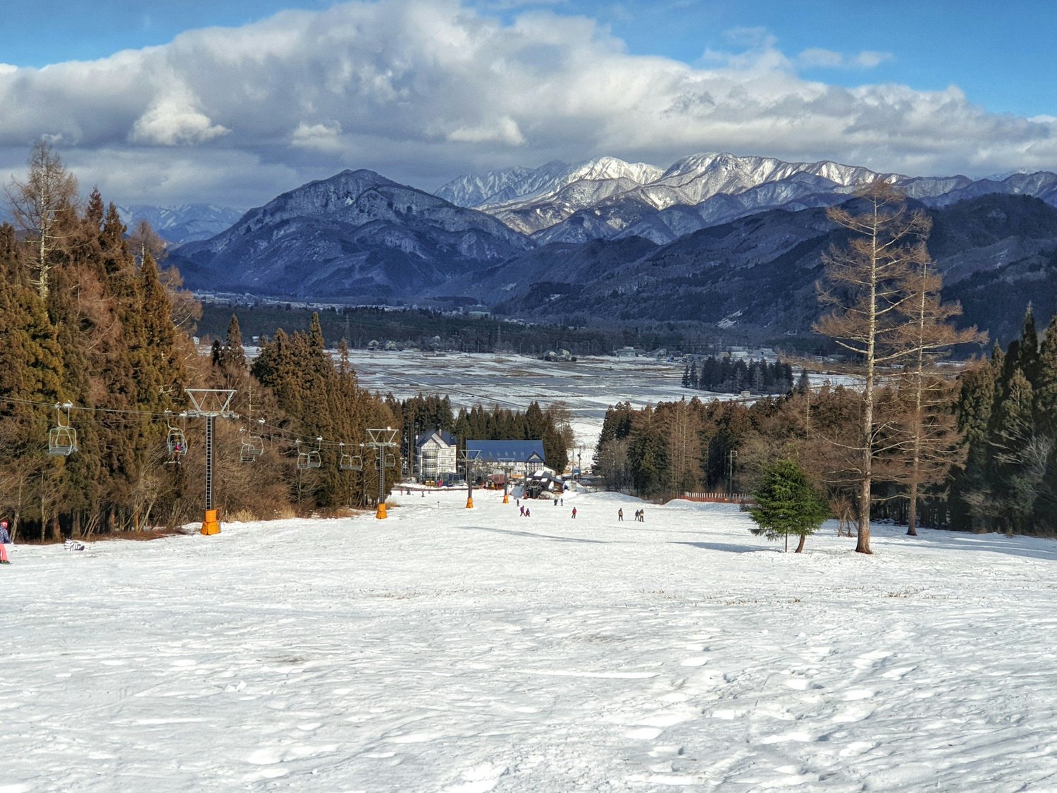 Snow-covered ski slopes overlooking Hakuba valley and the Japanese Alps